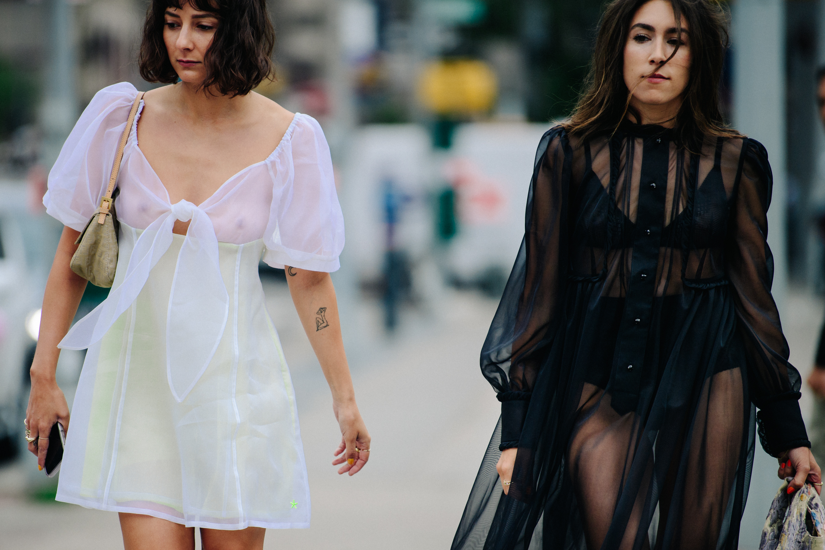 Two women wearing white and black lace dresses