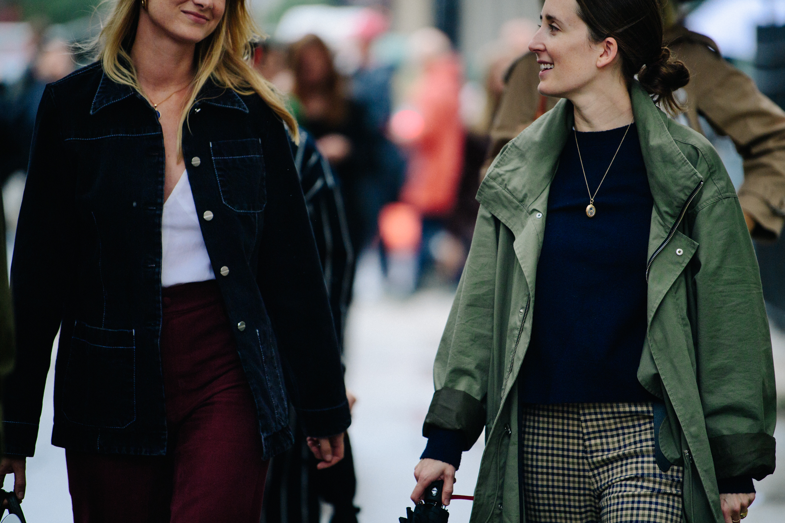 Two women wearing light coats