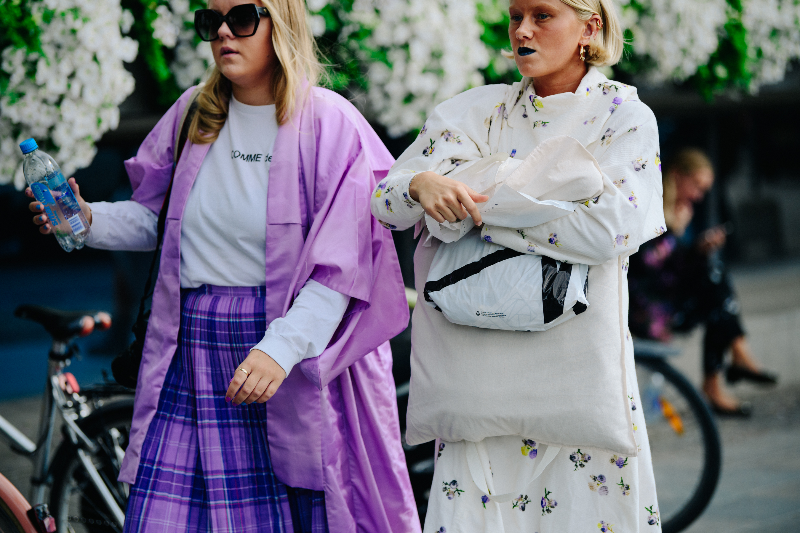 Two women wearing white and purple