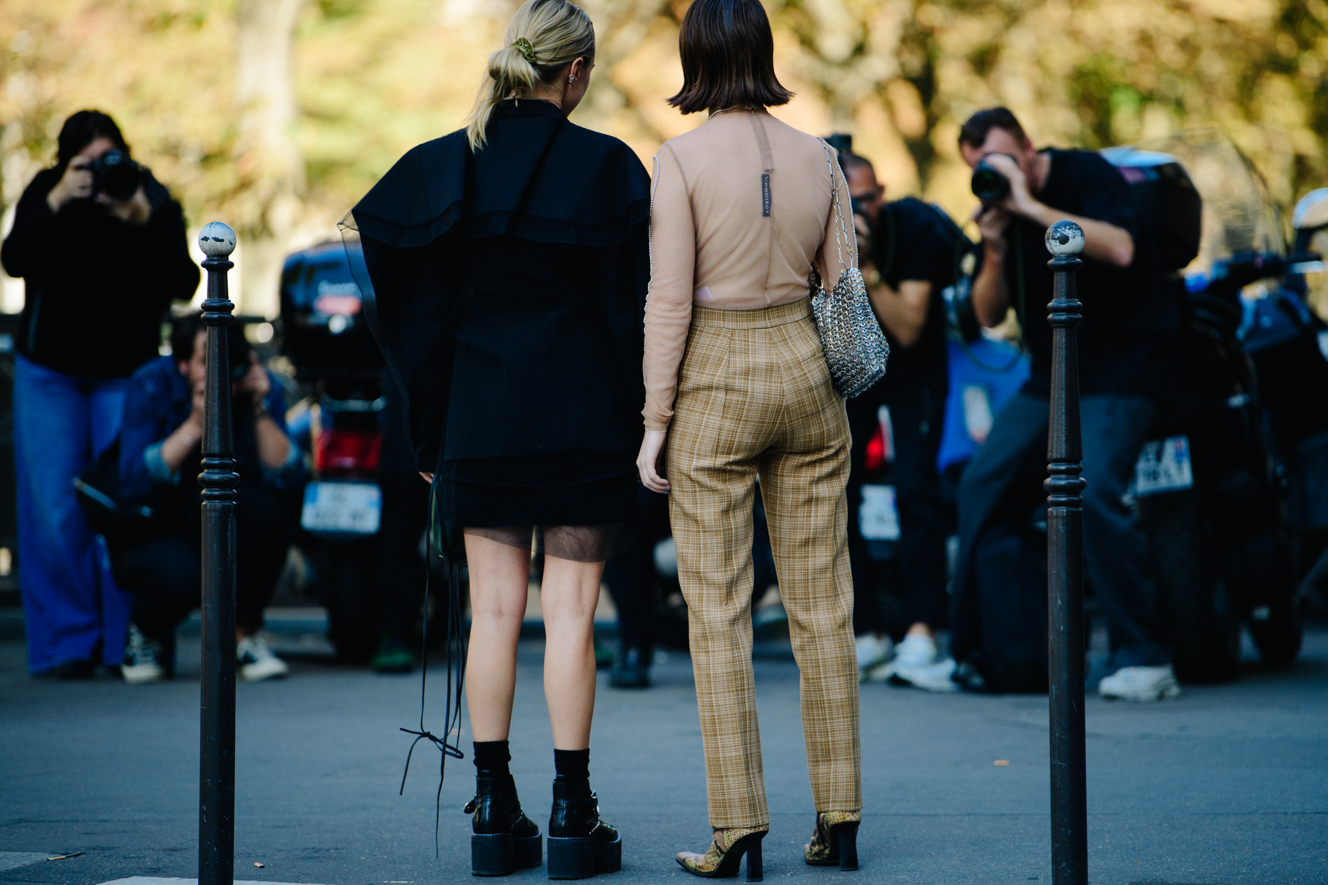 Two women wearing dark and light outfits