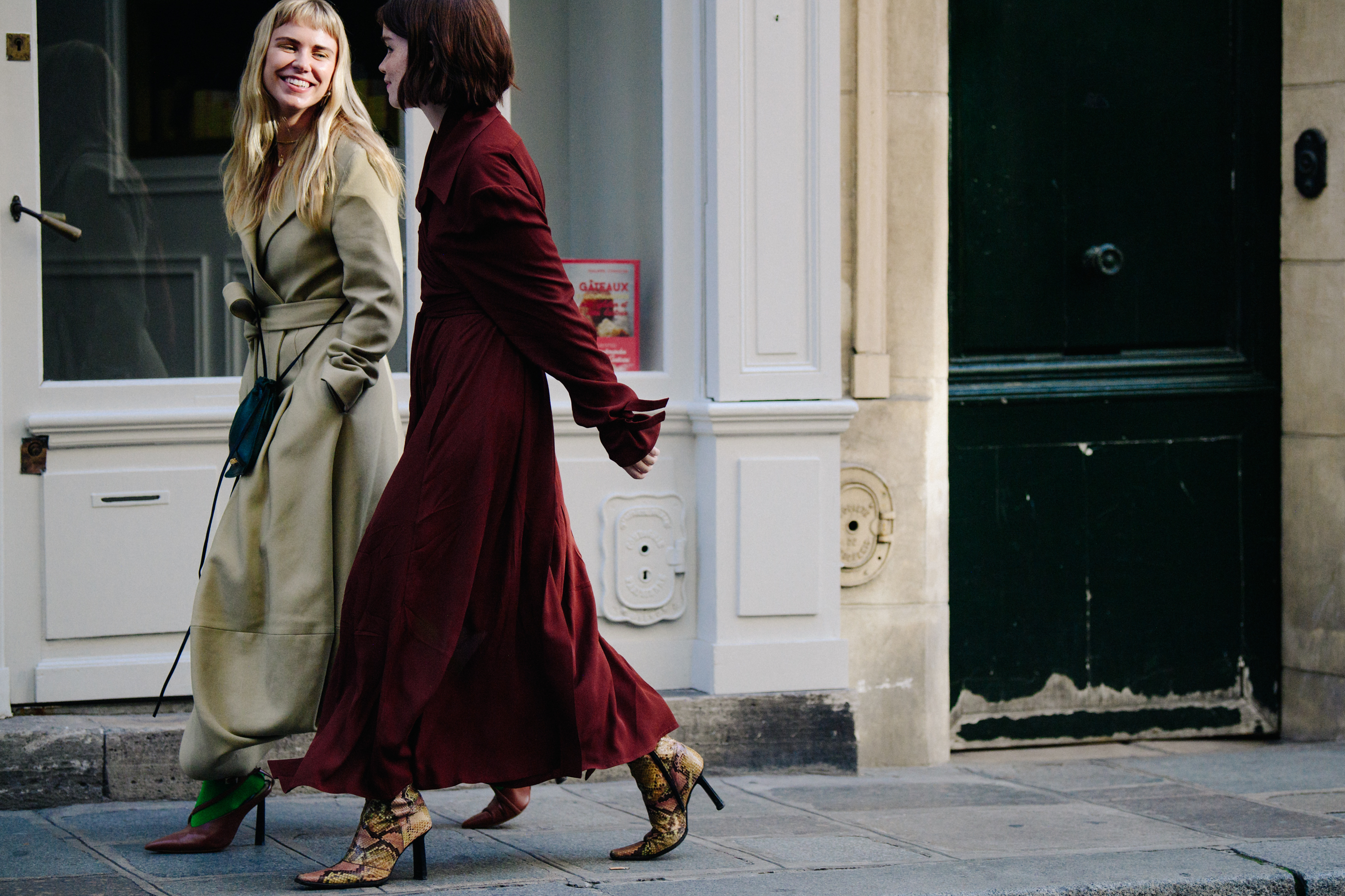 Two women wearing long coats