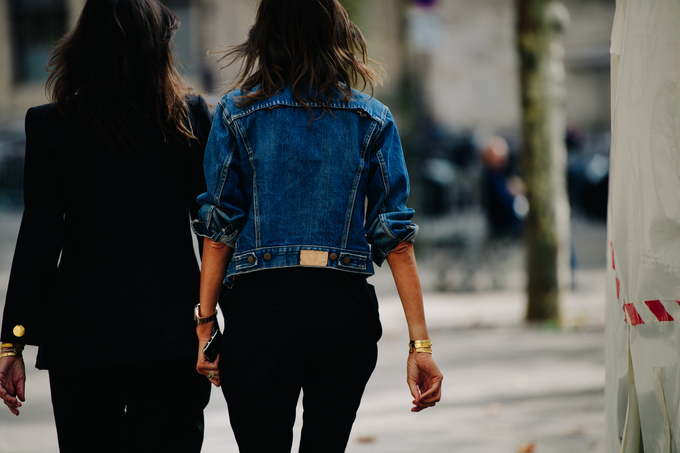 Two women wearing dark and denim jackets