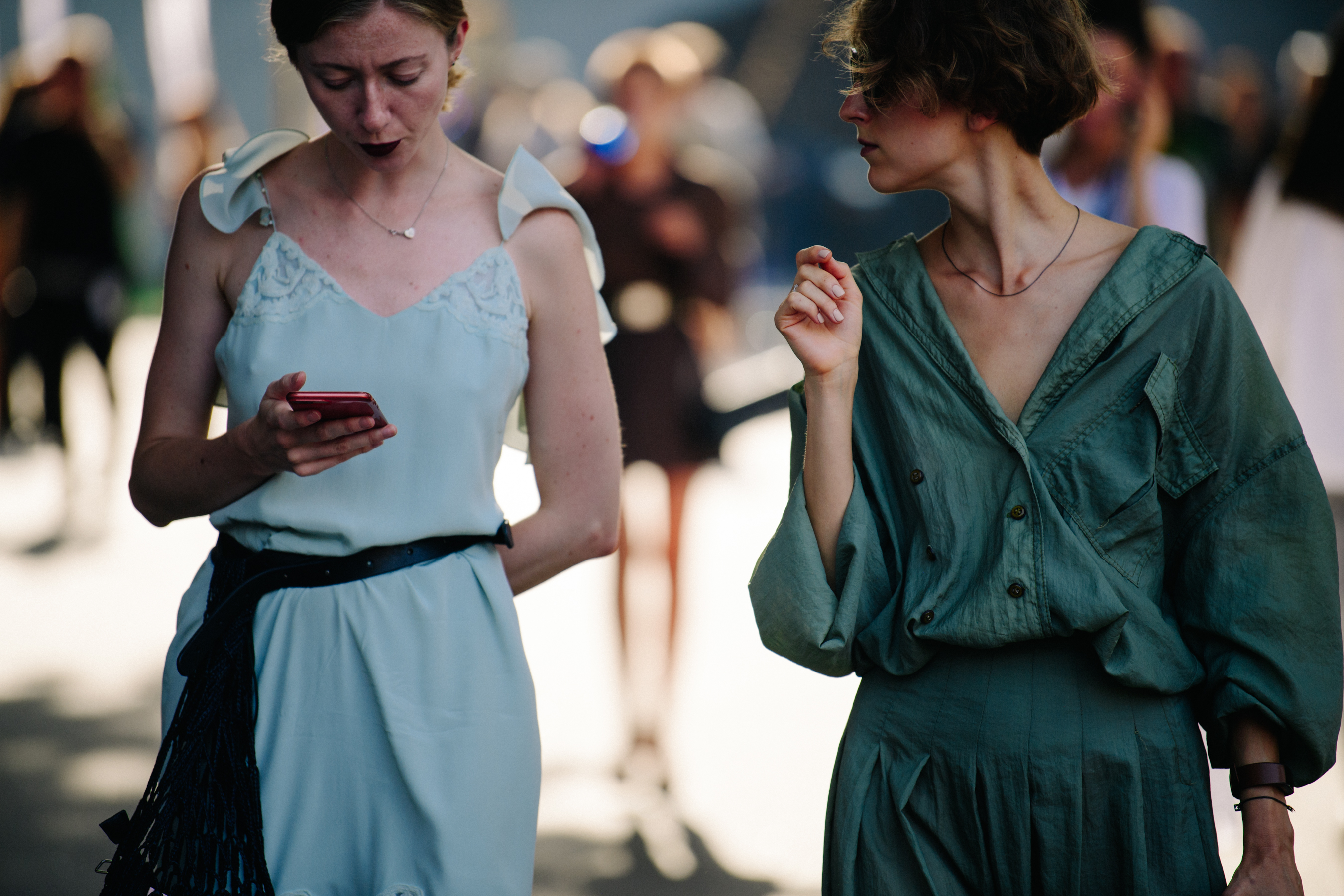 Two women wearing light dresses