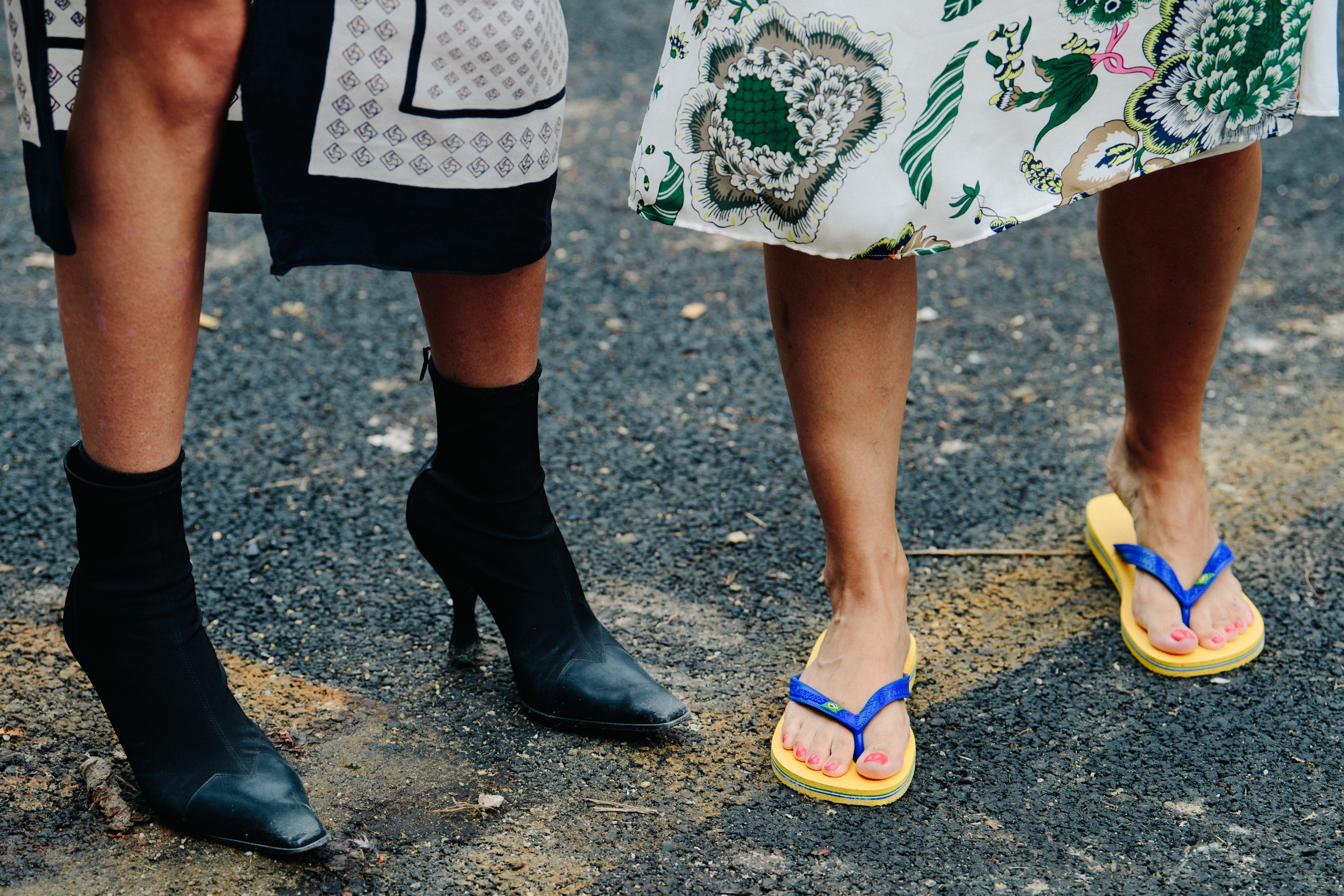 Two women wearing heels and flip flops