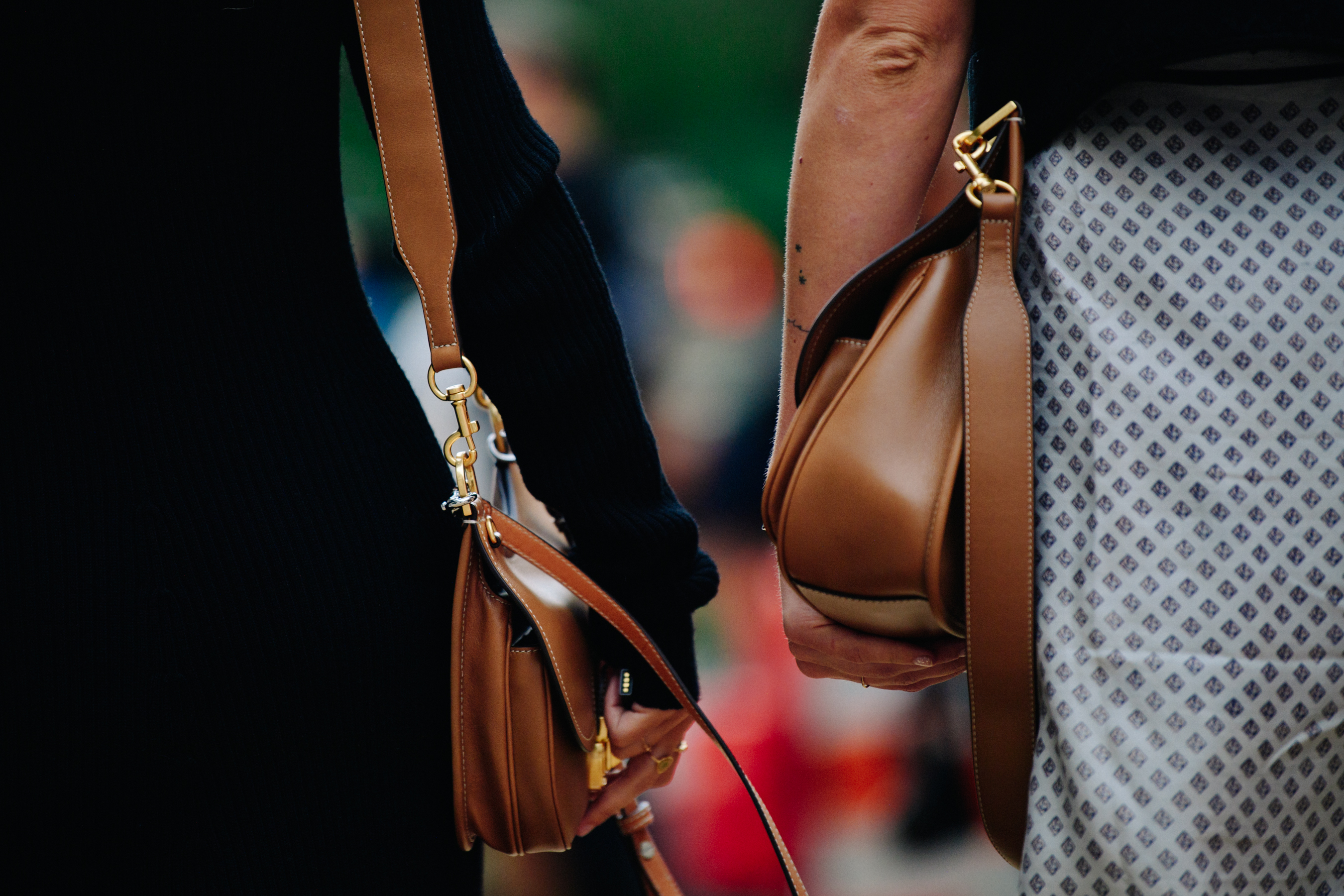 Two women carrying brown bags