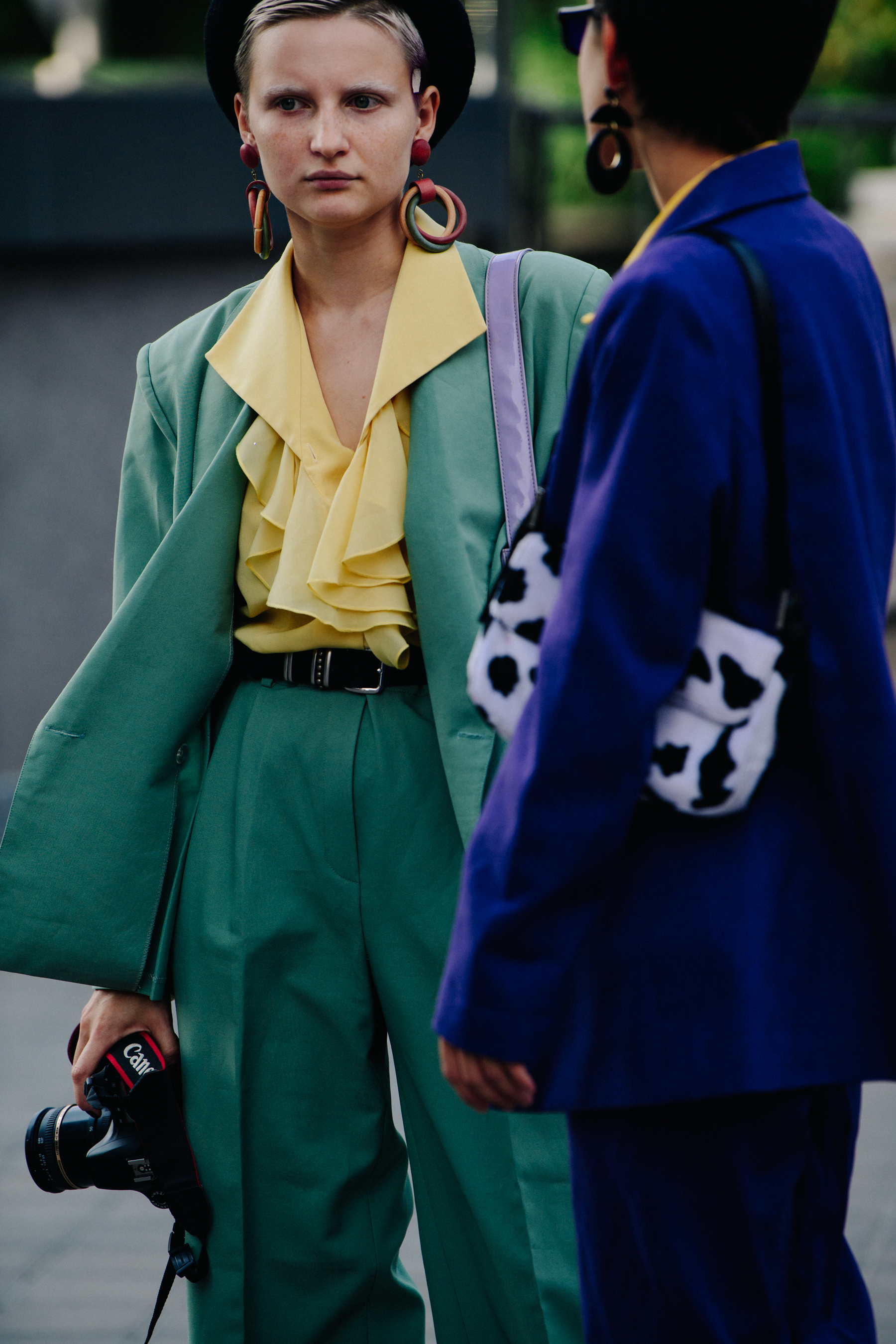 Two women wearing green and blue suits