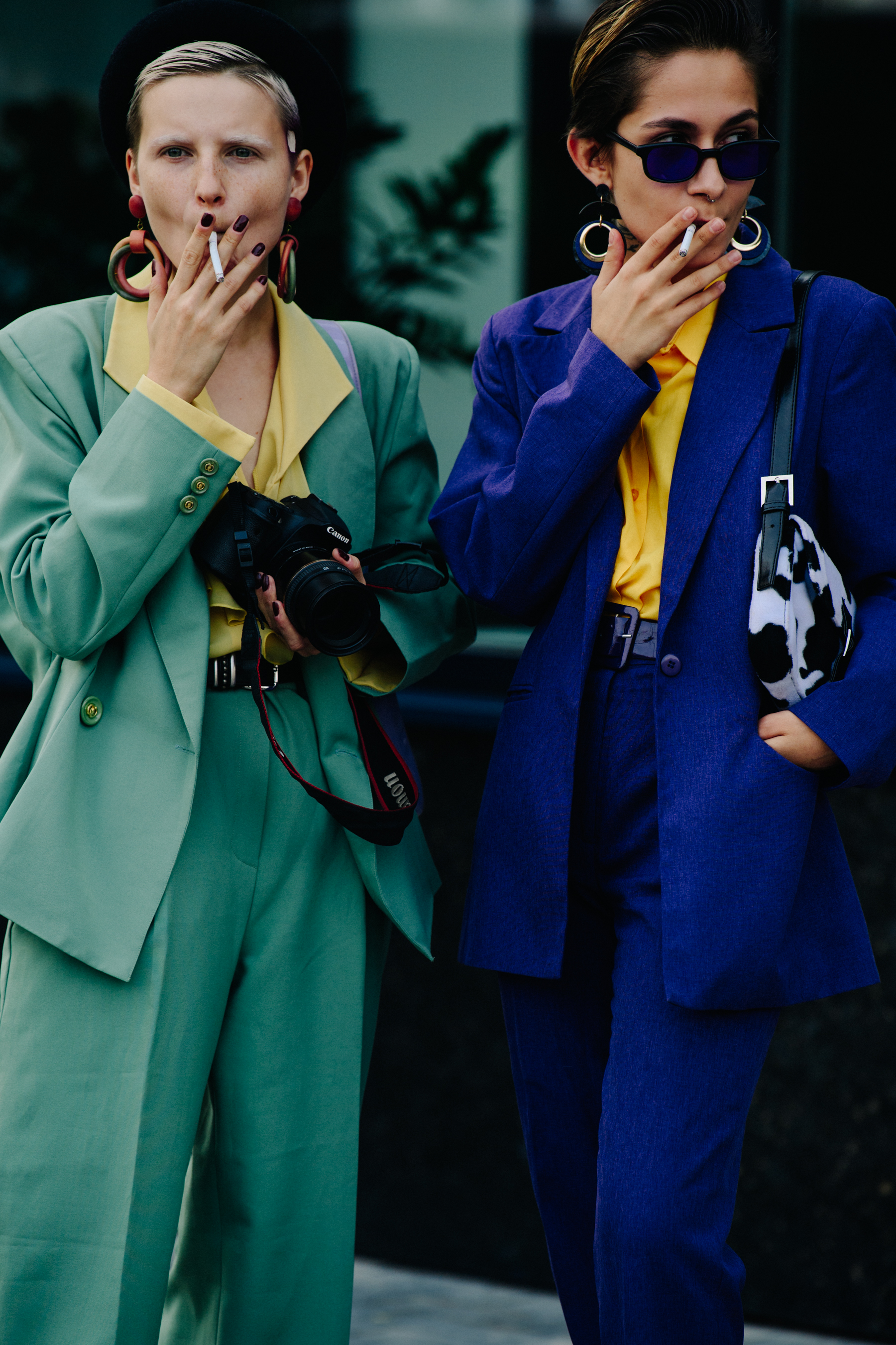 Two women wearing green and blue suits