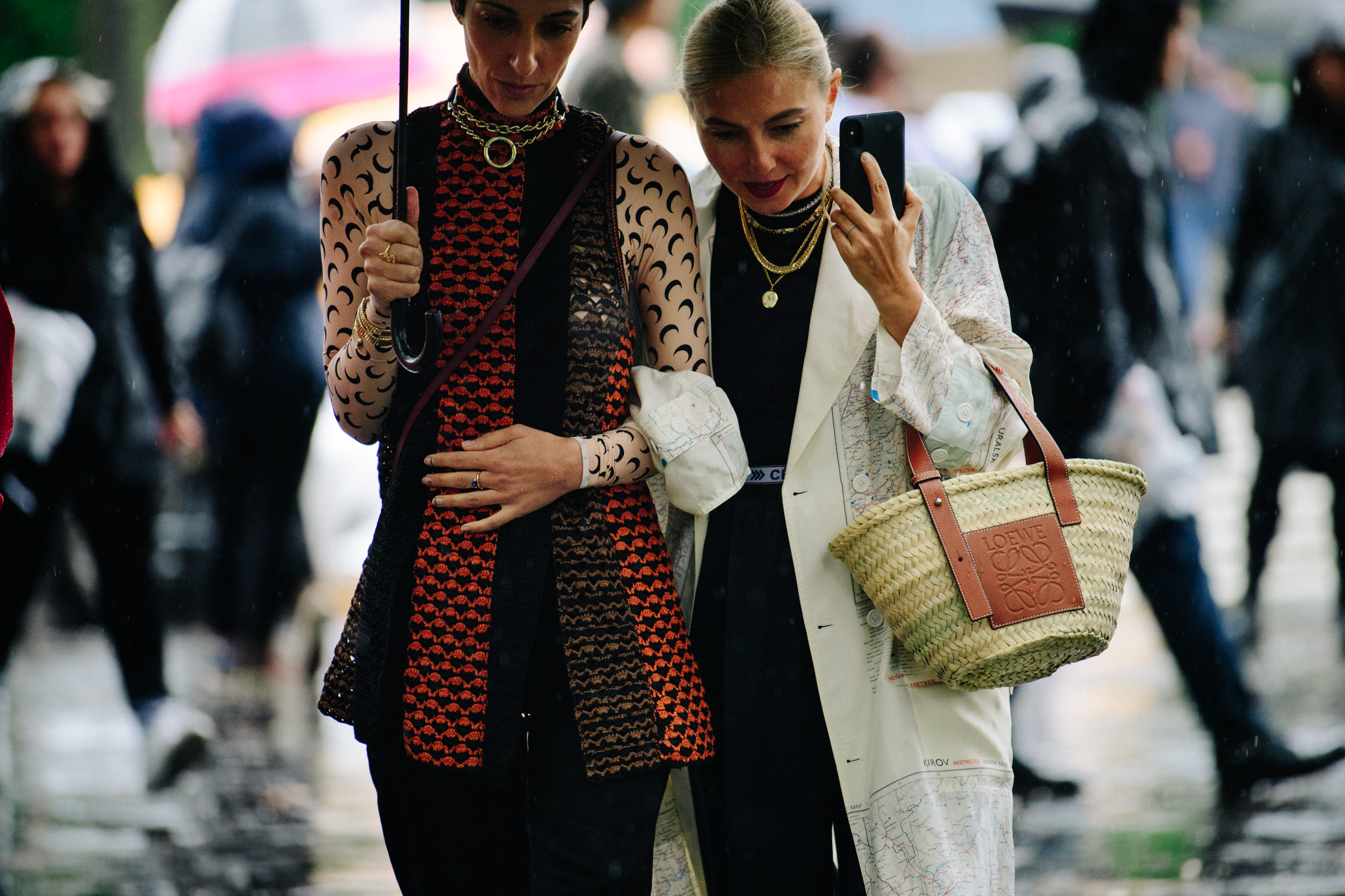 Two women wearing designer outfits