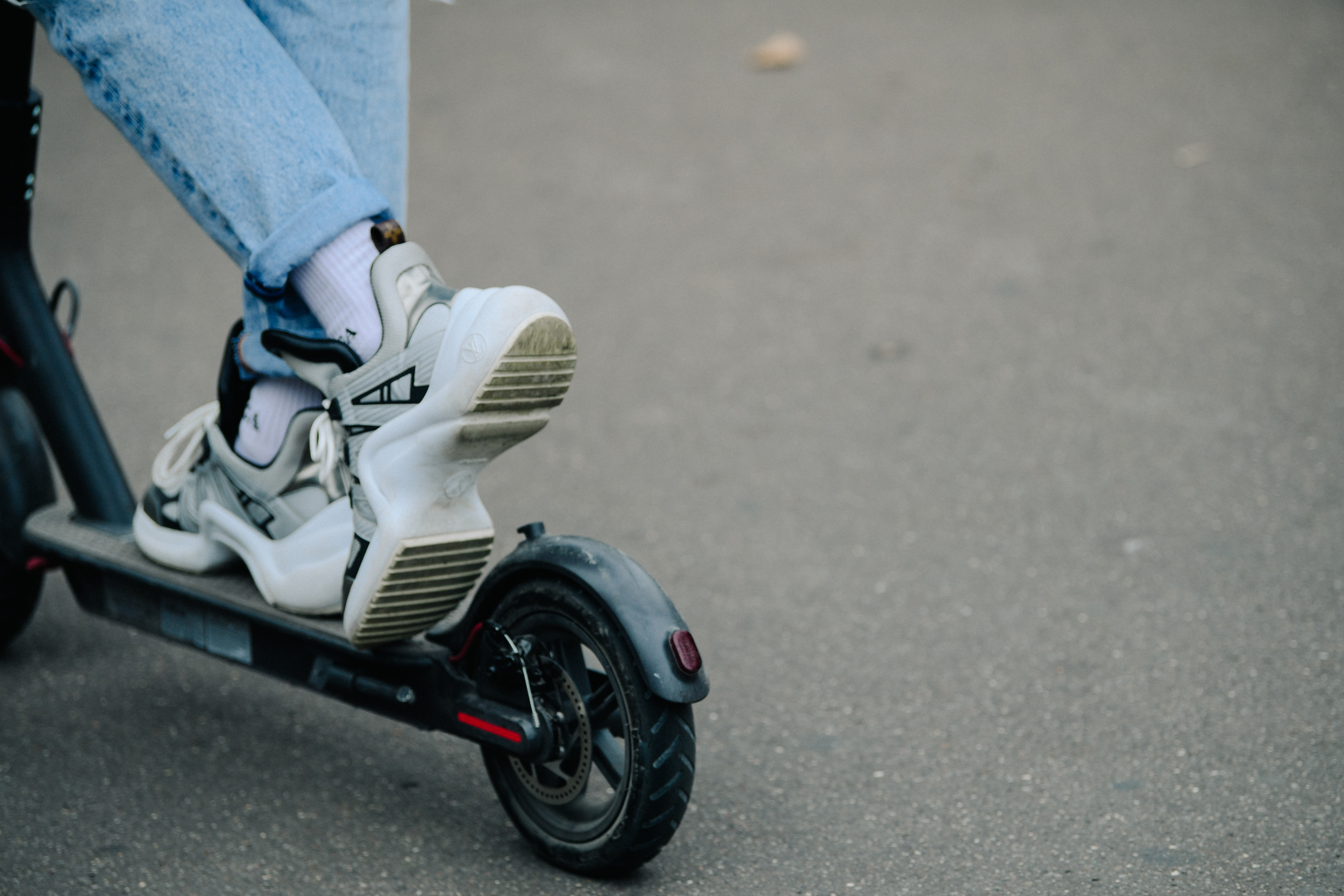 Woman riding scooter in Louis Vuitton shoes