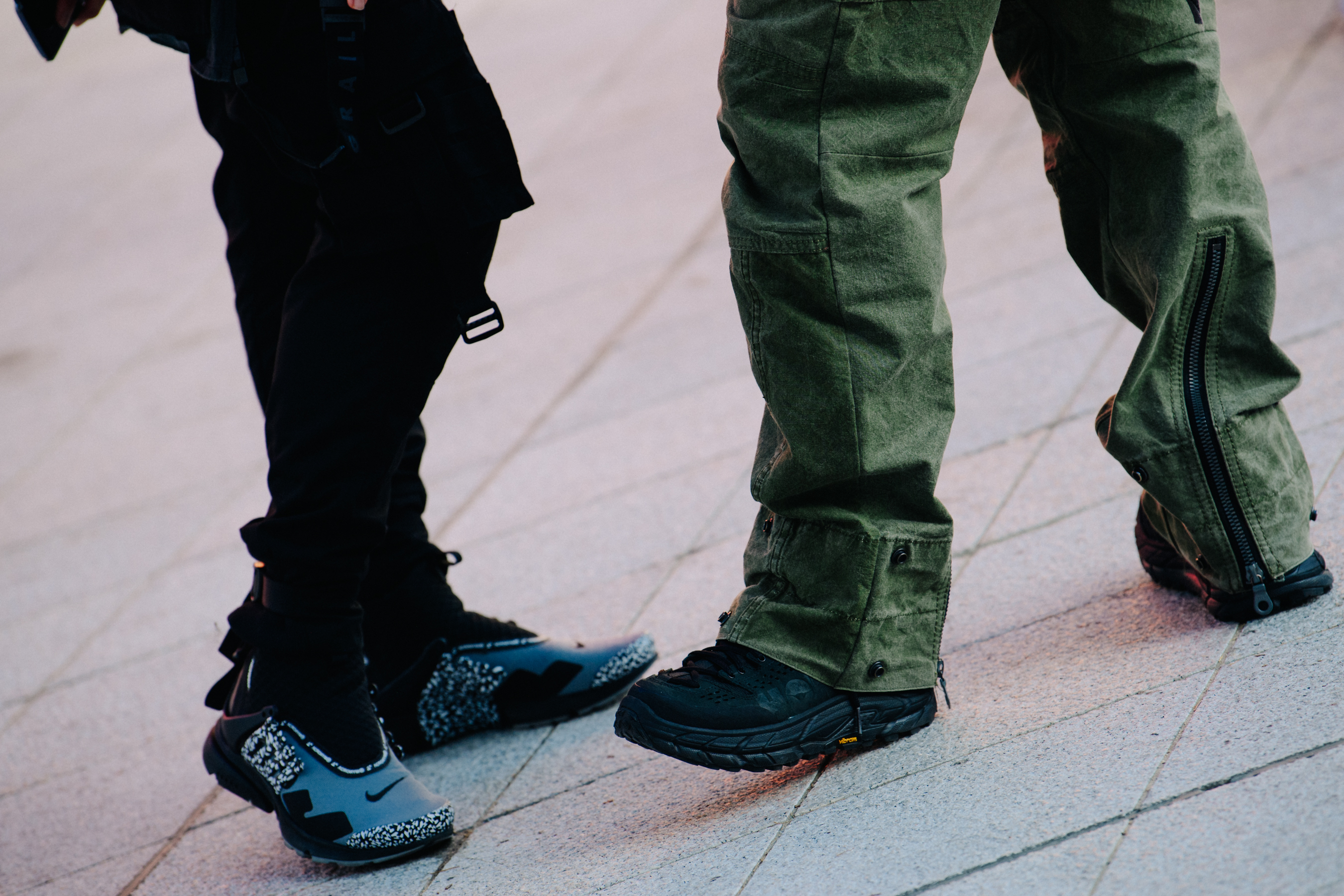 Two men wearing Nike and Hoka sneakers