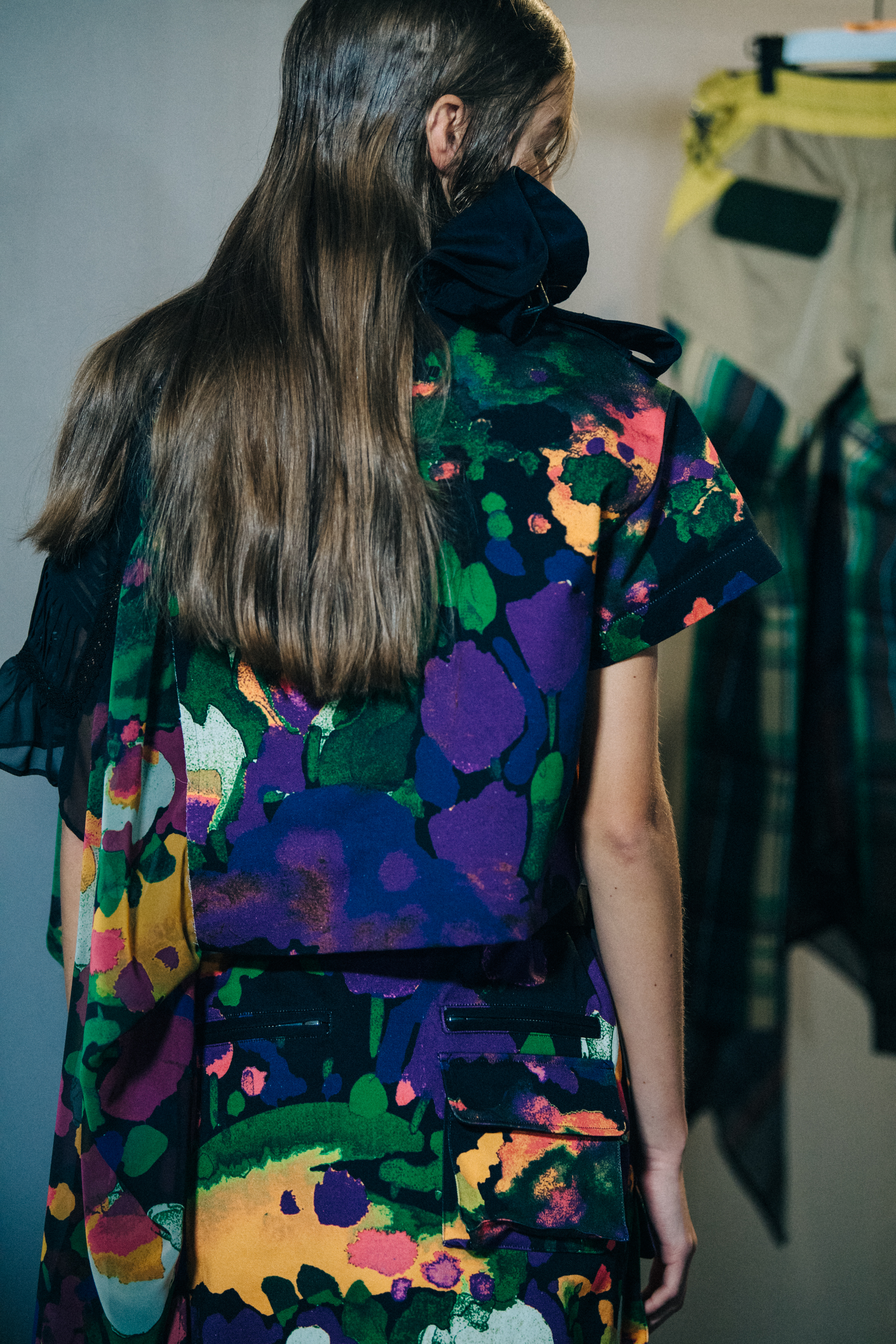 Models wearing colourful Sacai outfits backstage