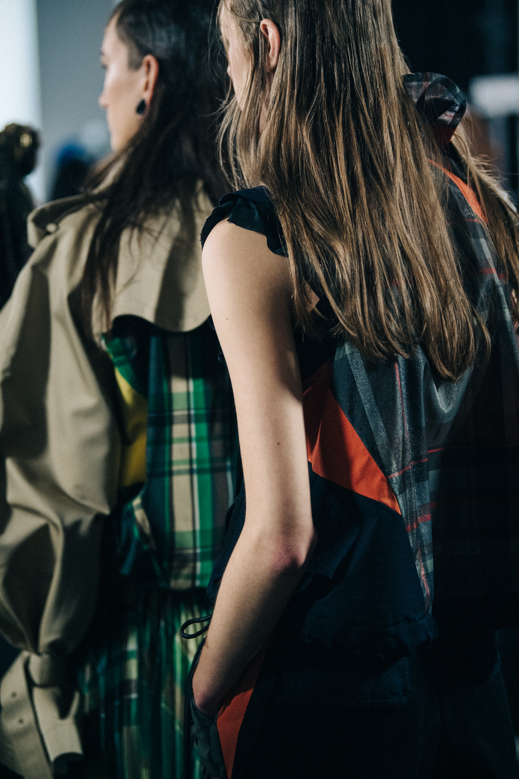 Models wearing colourful Sacai outfits backstage