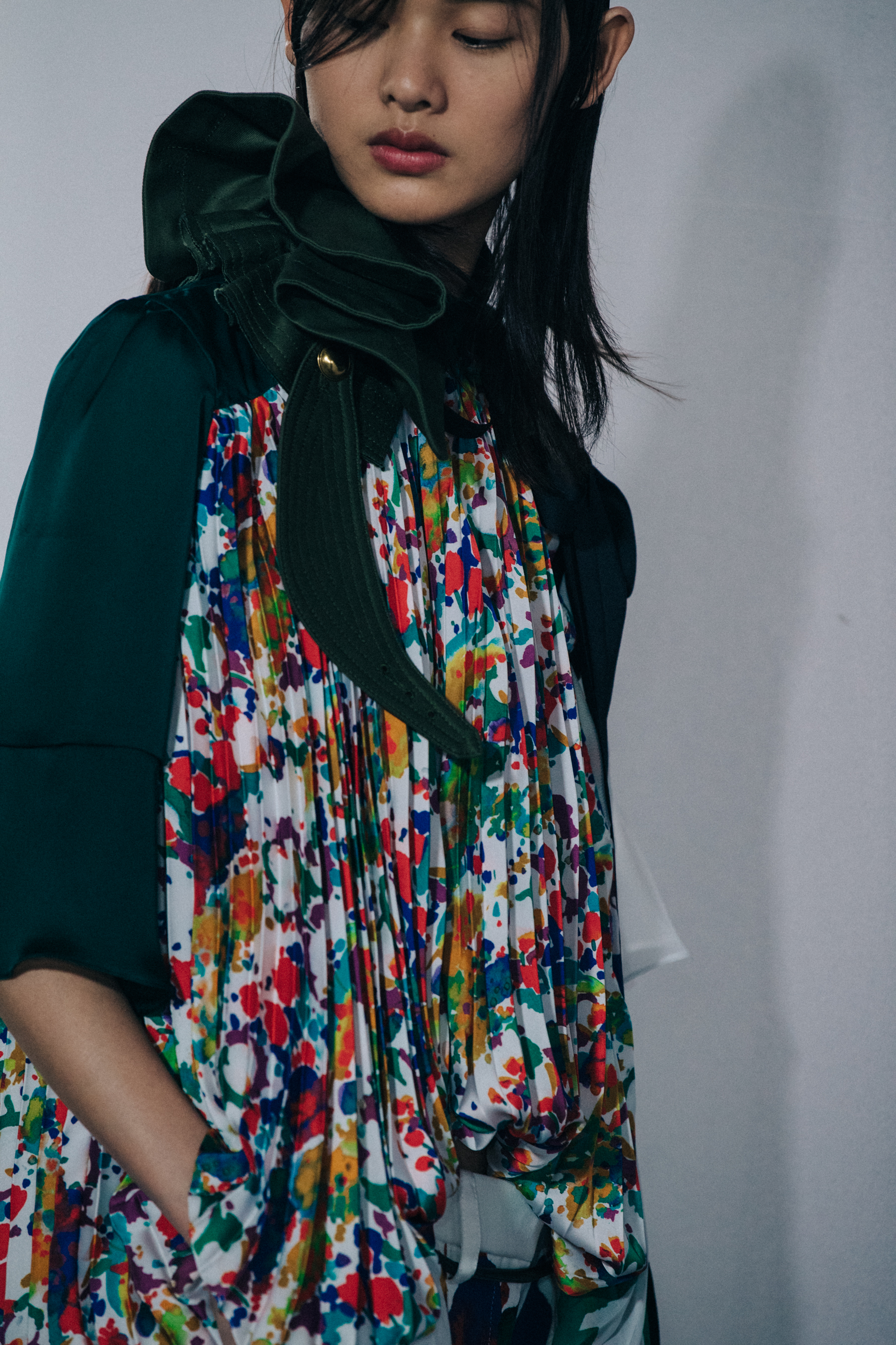Models wearing colourful Sacai outfits backstage