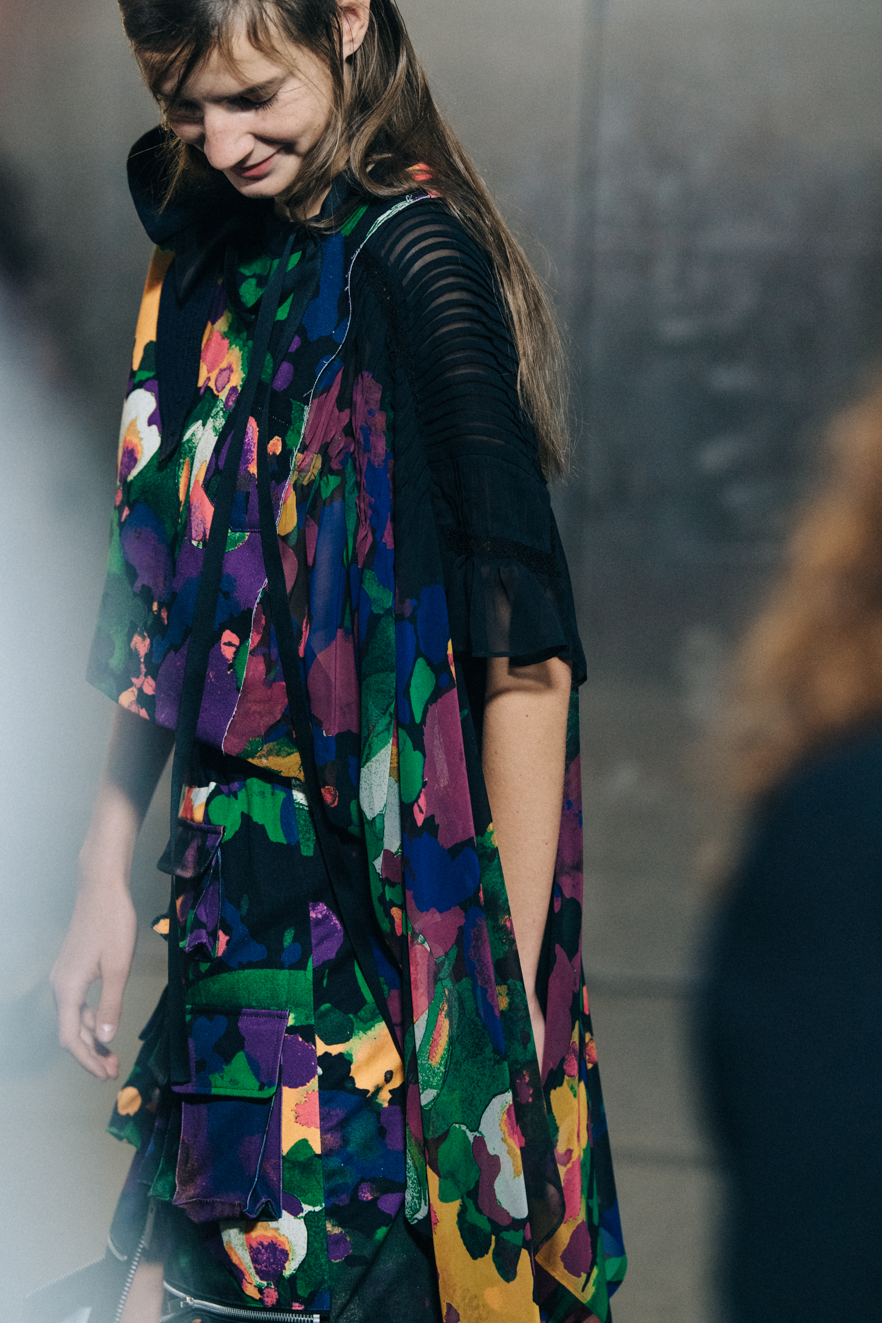 Models wearing colourful Sacai outfits backstage