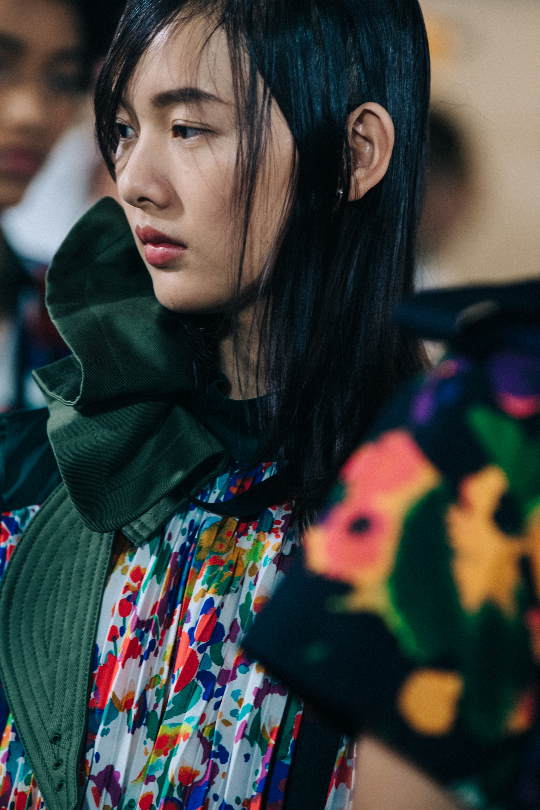 Models wearing colourful Sacai outfits backstage