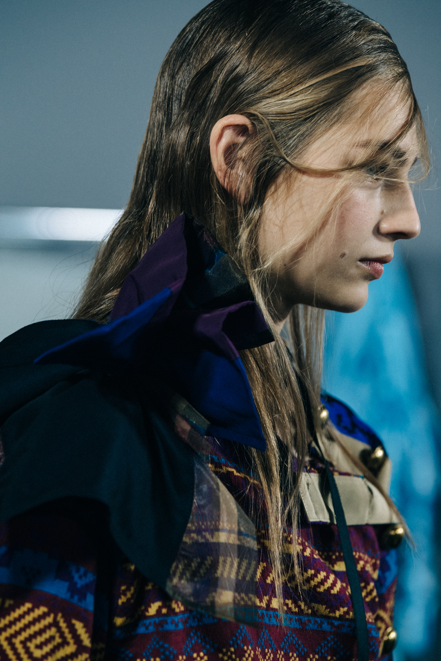 Models wearing colourful Sacai outfits backstage