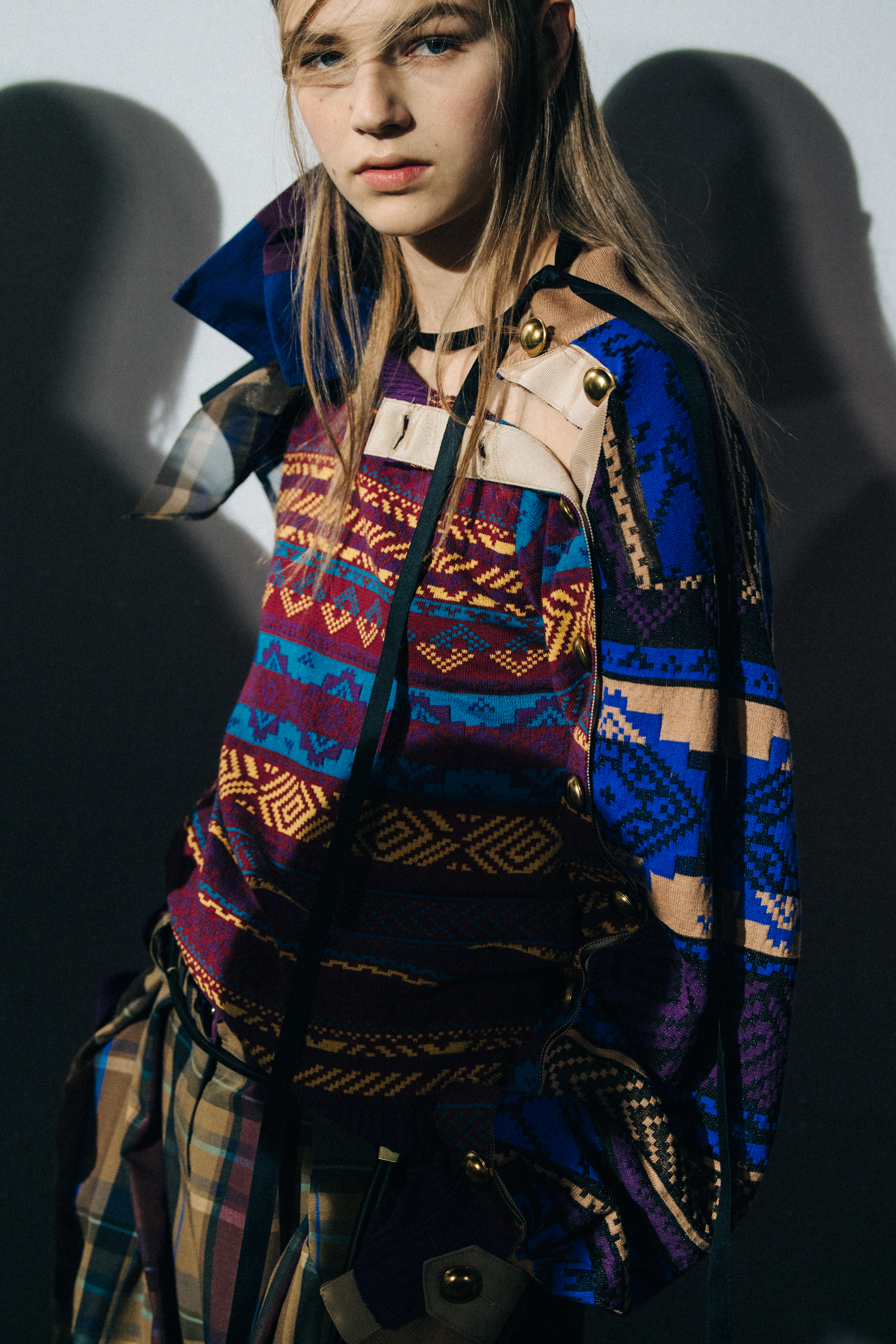 Models wearing colourful Sacai outfits backstage