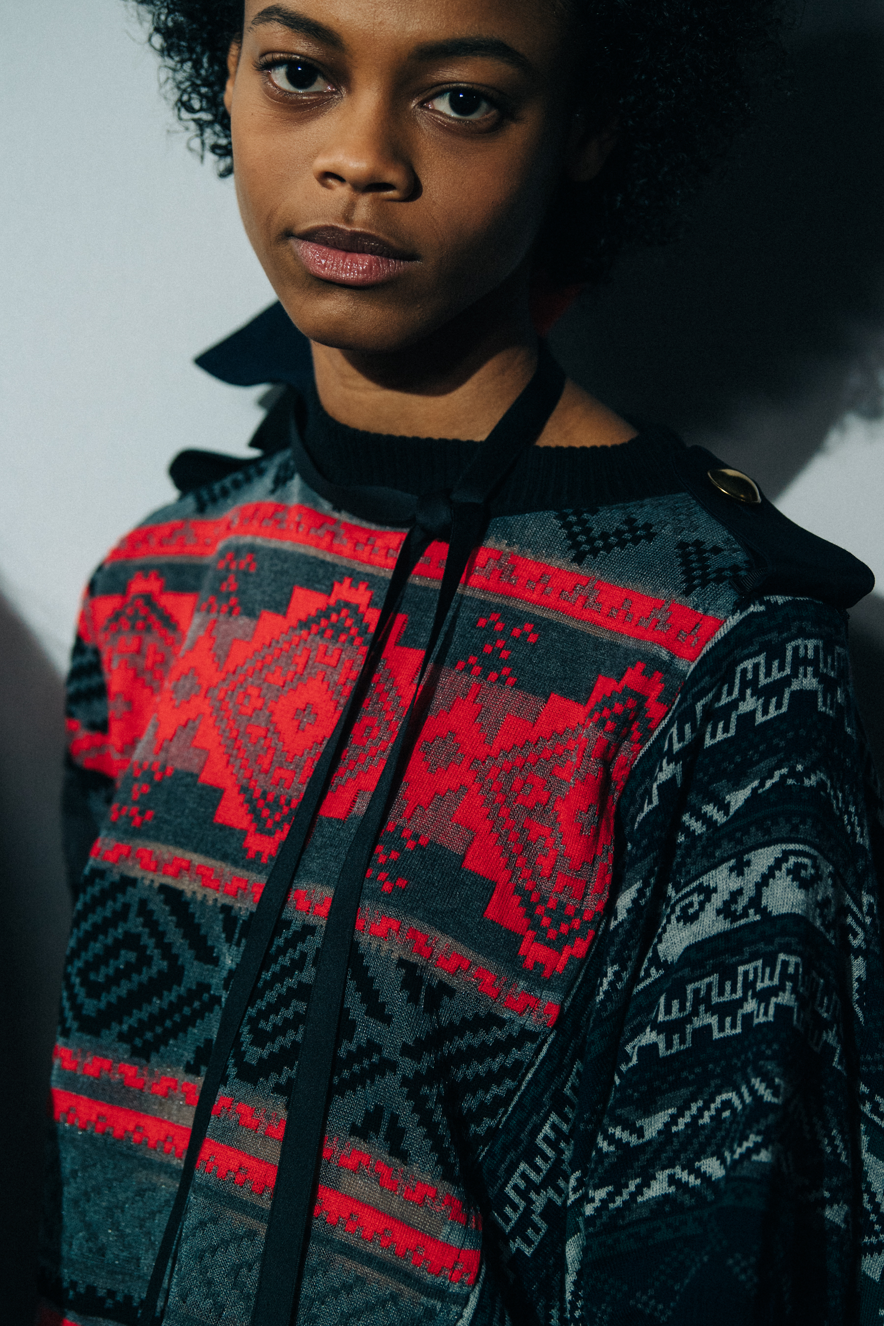 Models wearing colourful Sacai outfits backstage