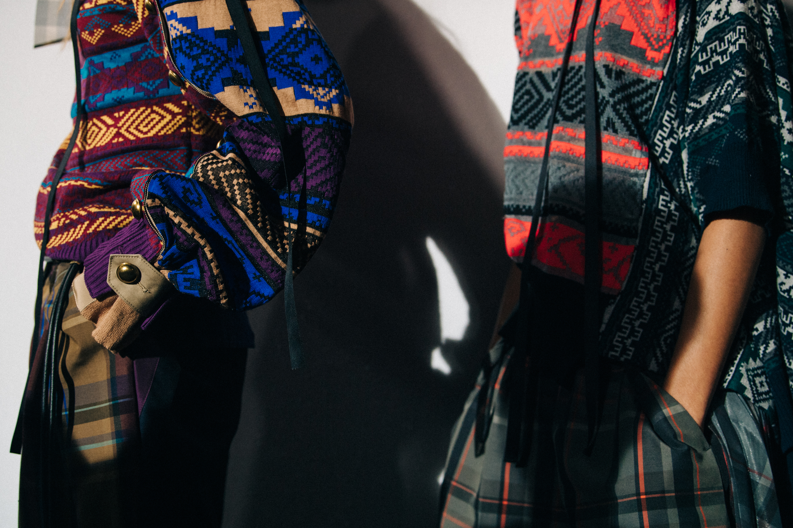 Models wearing colourful Sacai outfits backstage
