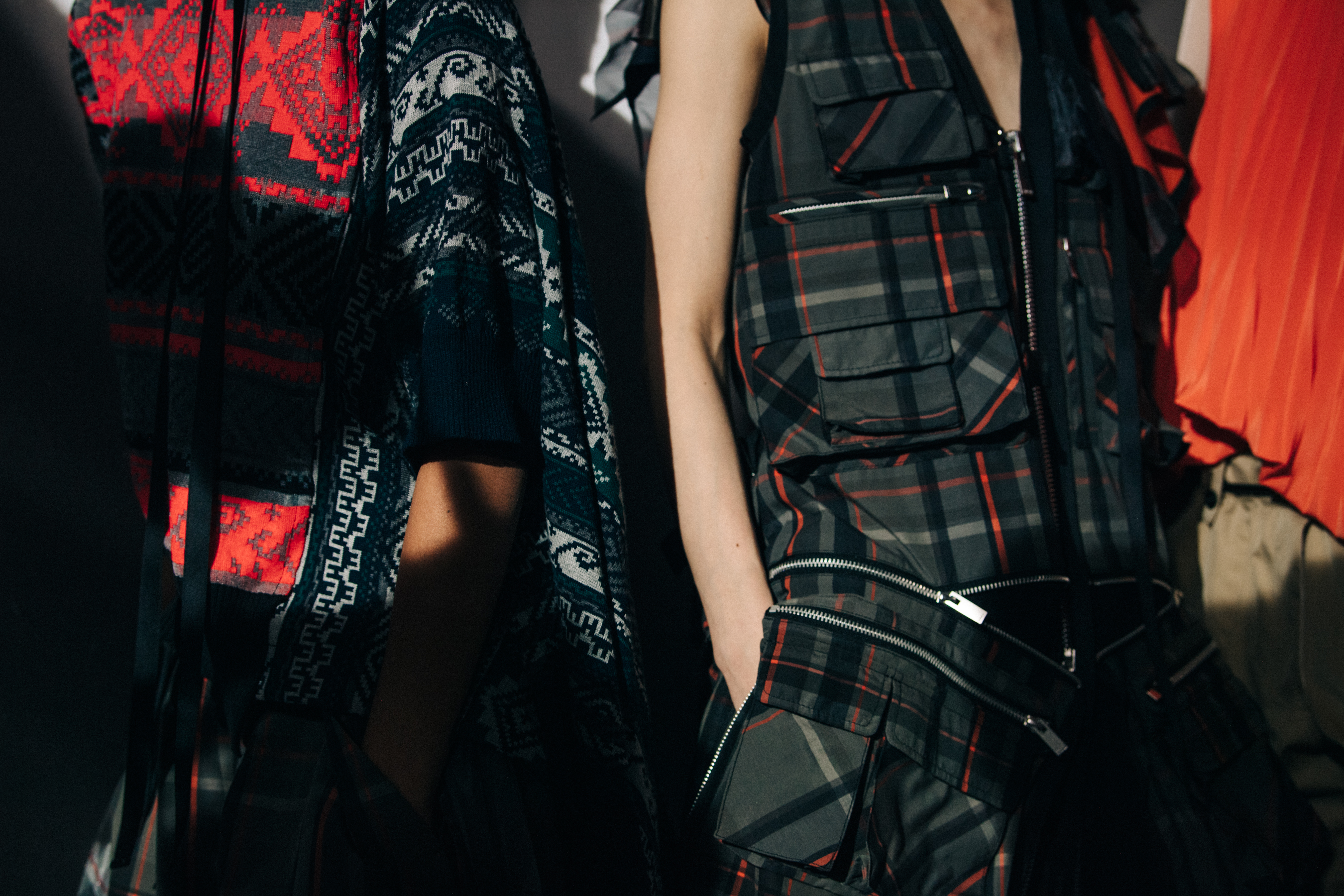 Models wearing colourful Sacai outfits backstage