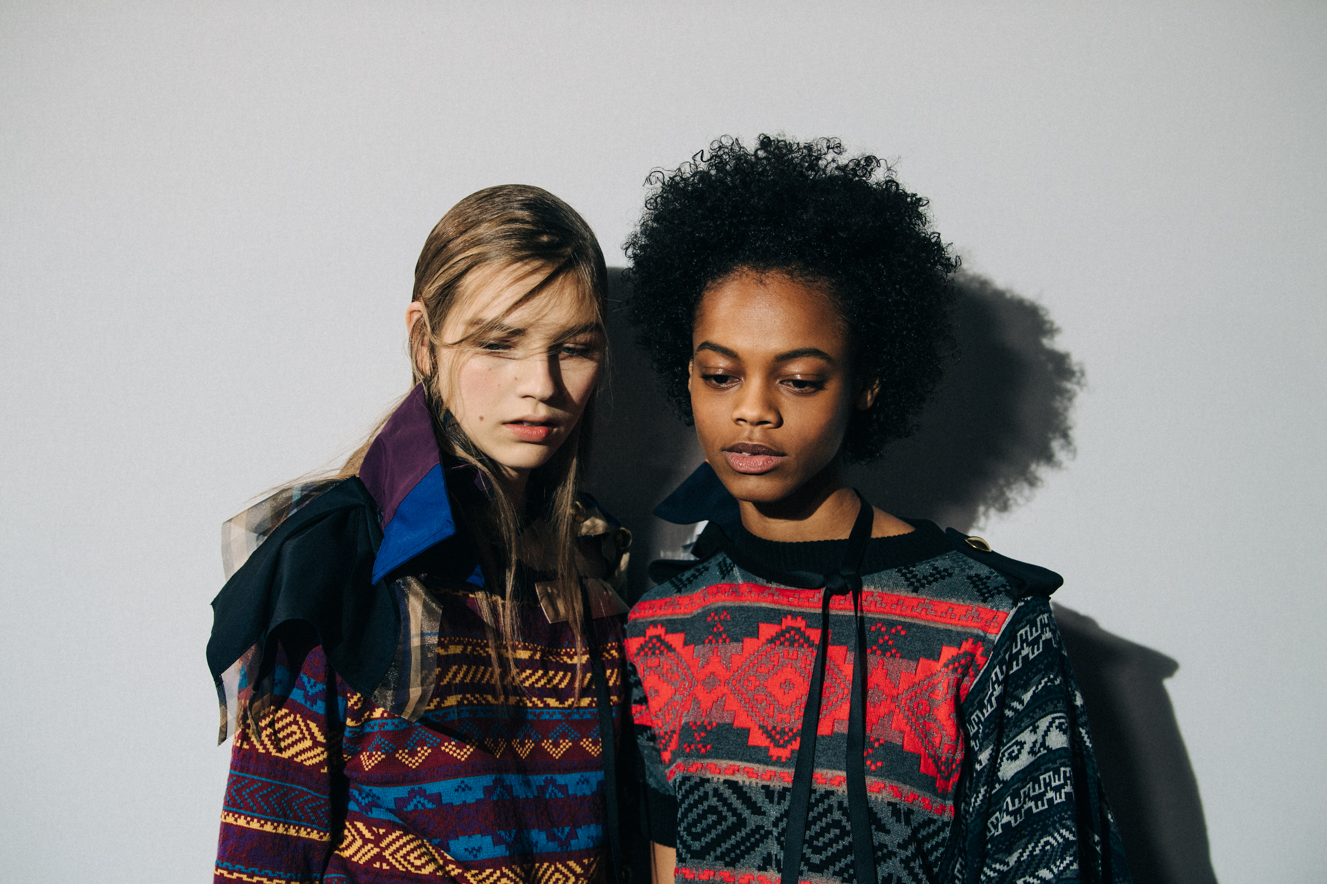Models wearing colourful Sacai outfits backstage