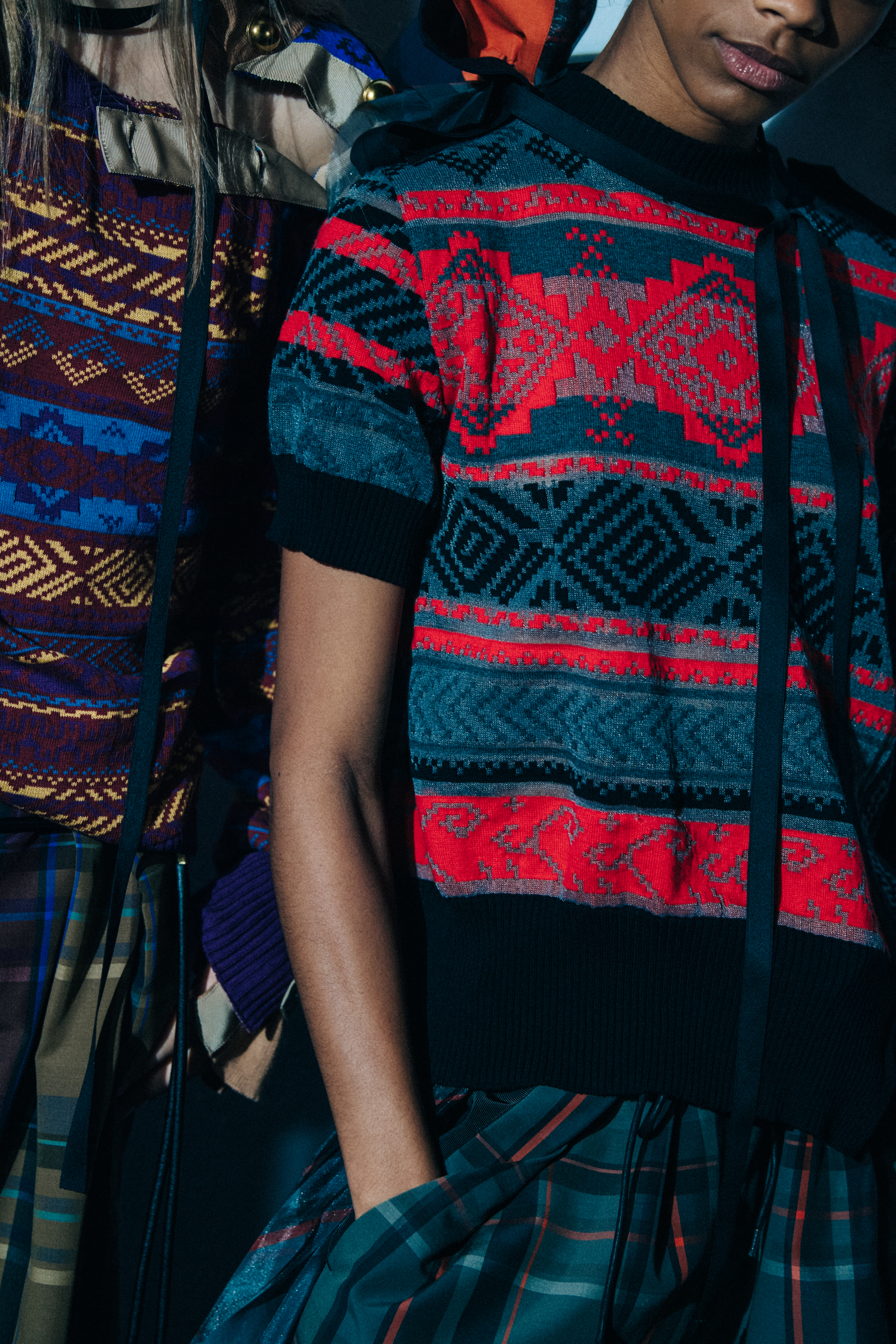 Models wearing colourful Sacai outfits backstage