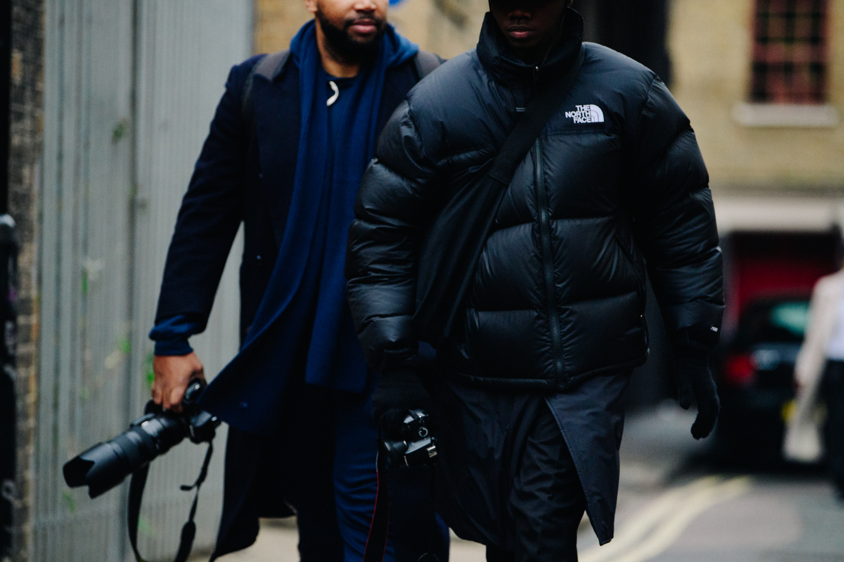 Two men wearing black coats