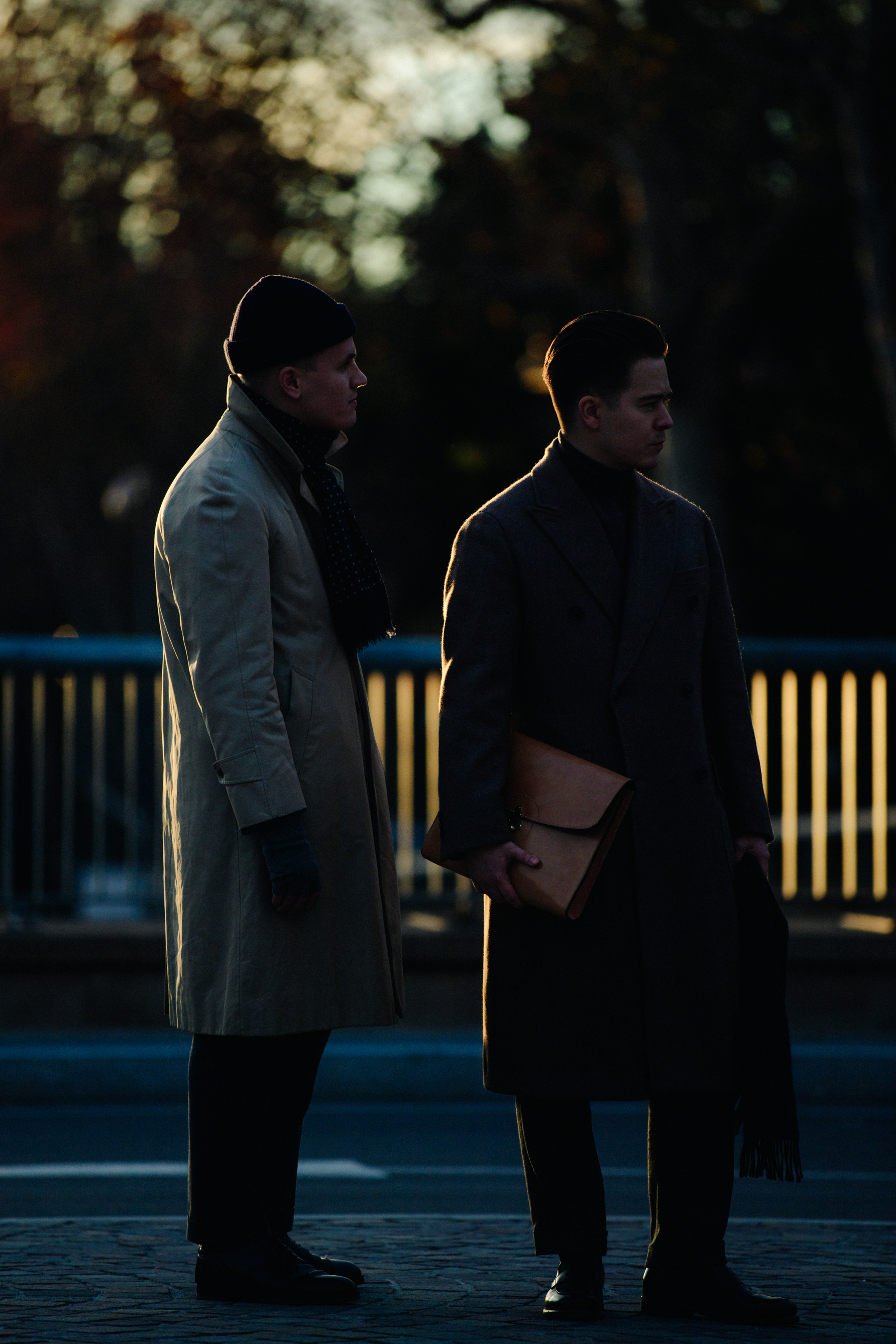 Two men wearing long coats