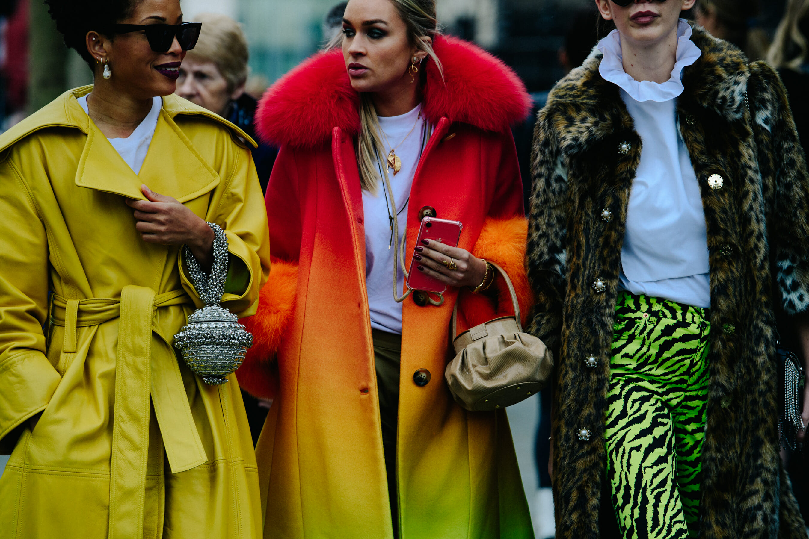 Three women wearing colourful coats
