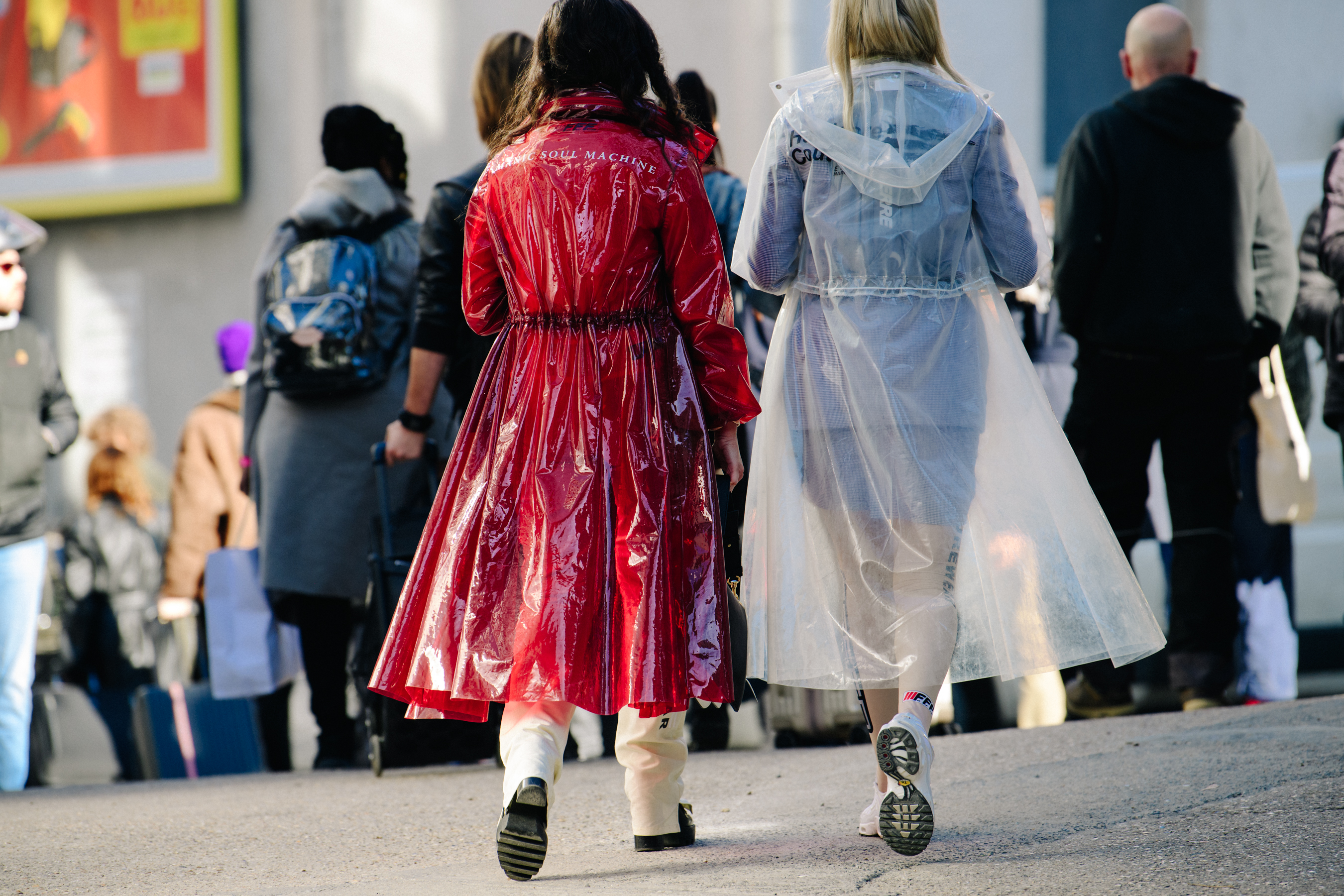 Two women wearing white and red coats