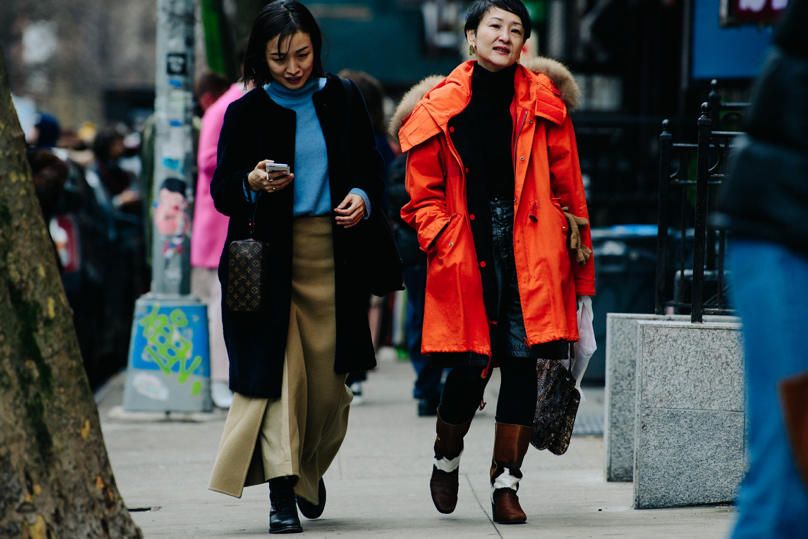 Two women wearing red and blue coats