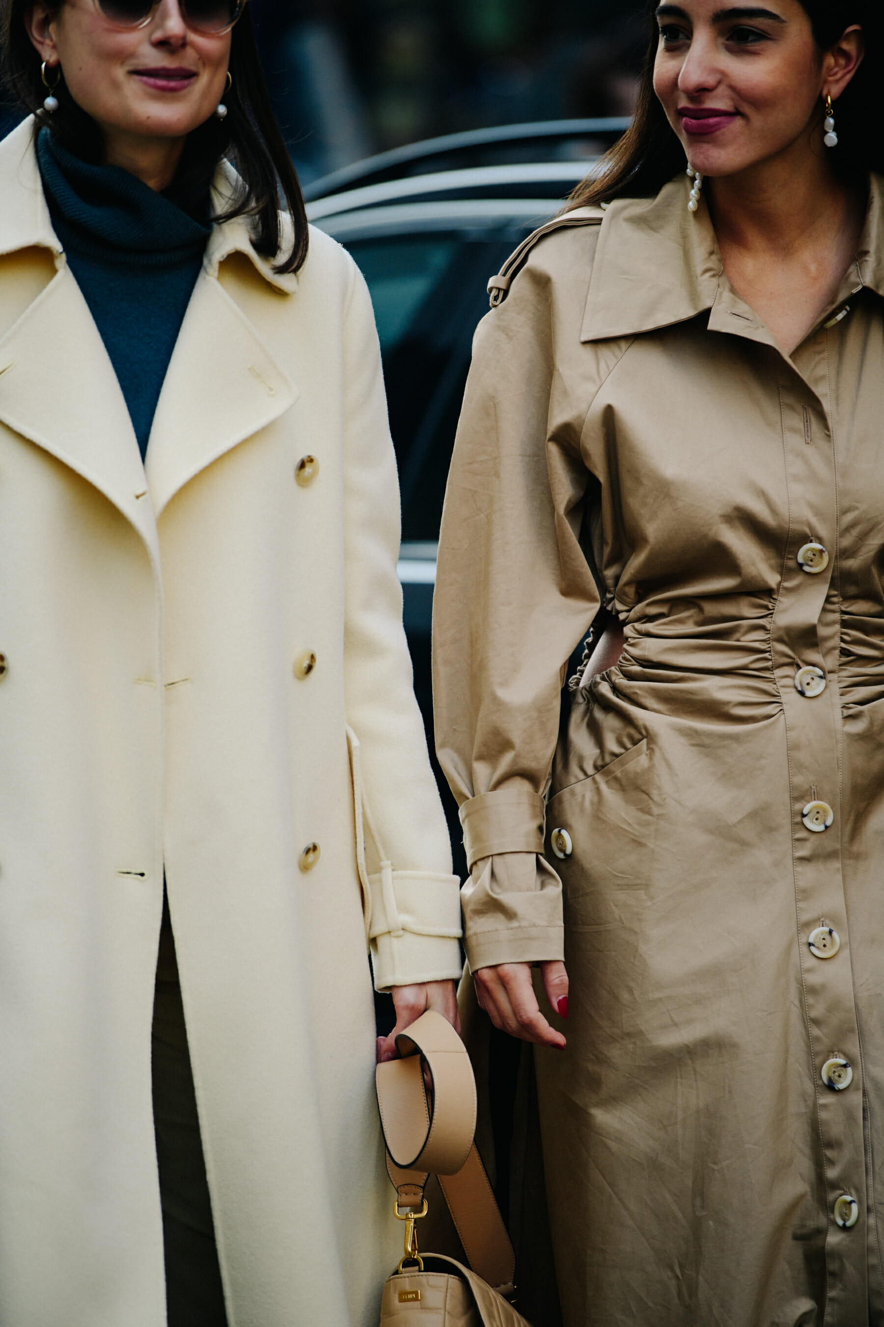 Two women wearing long coats