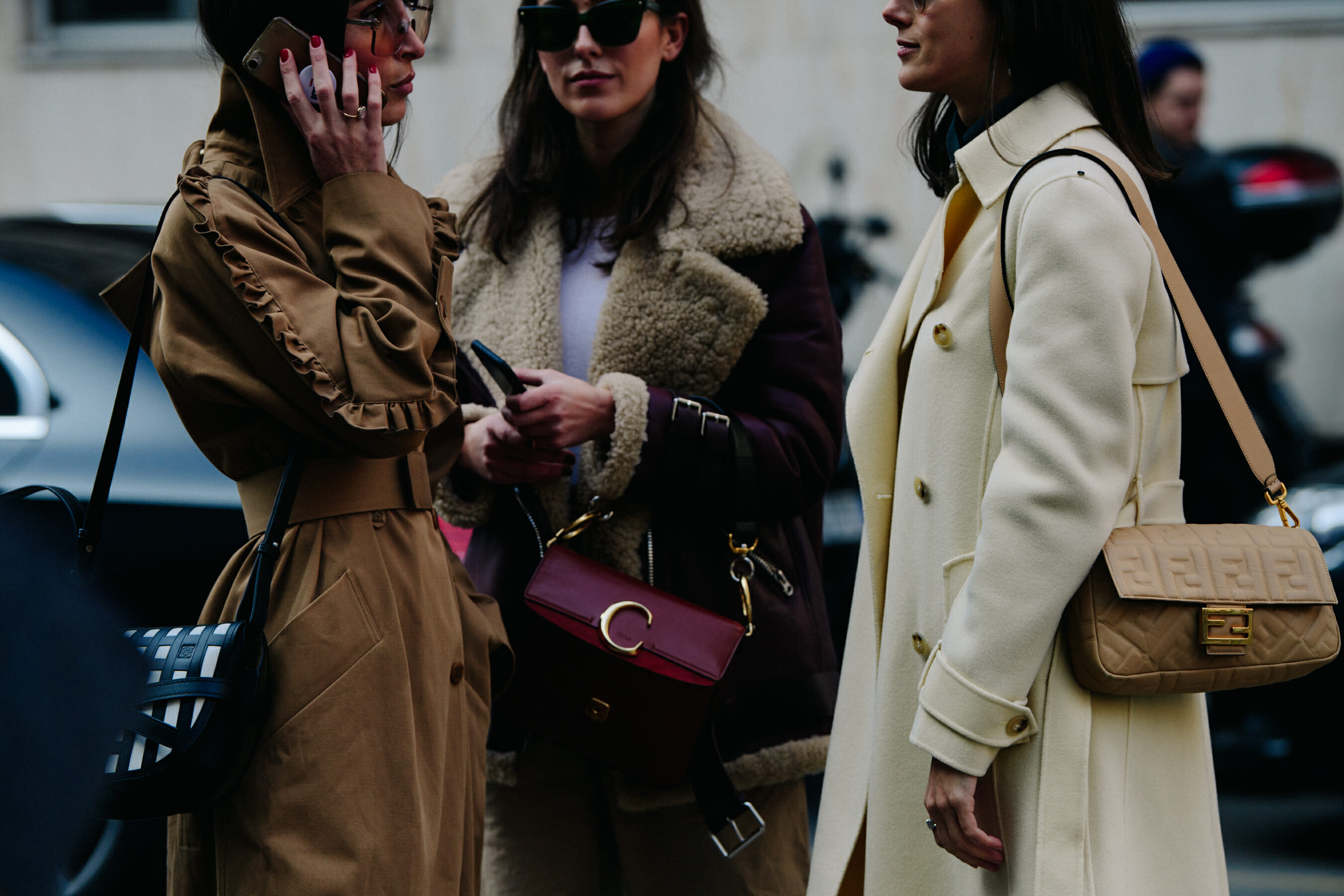 Three women wearing long coats