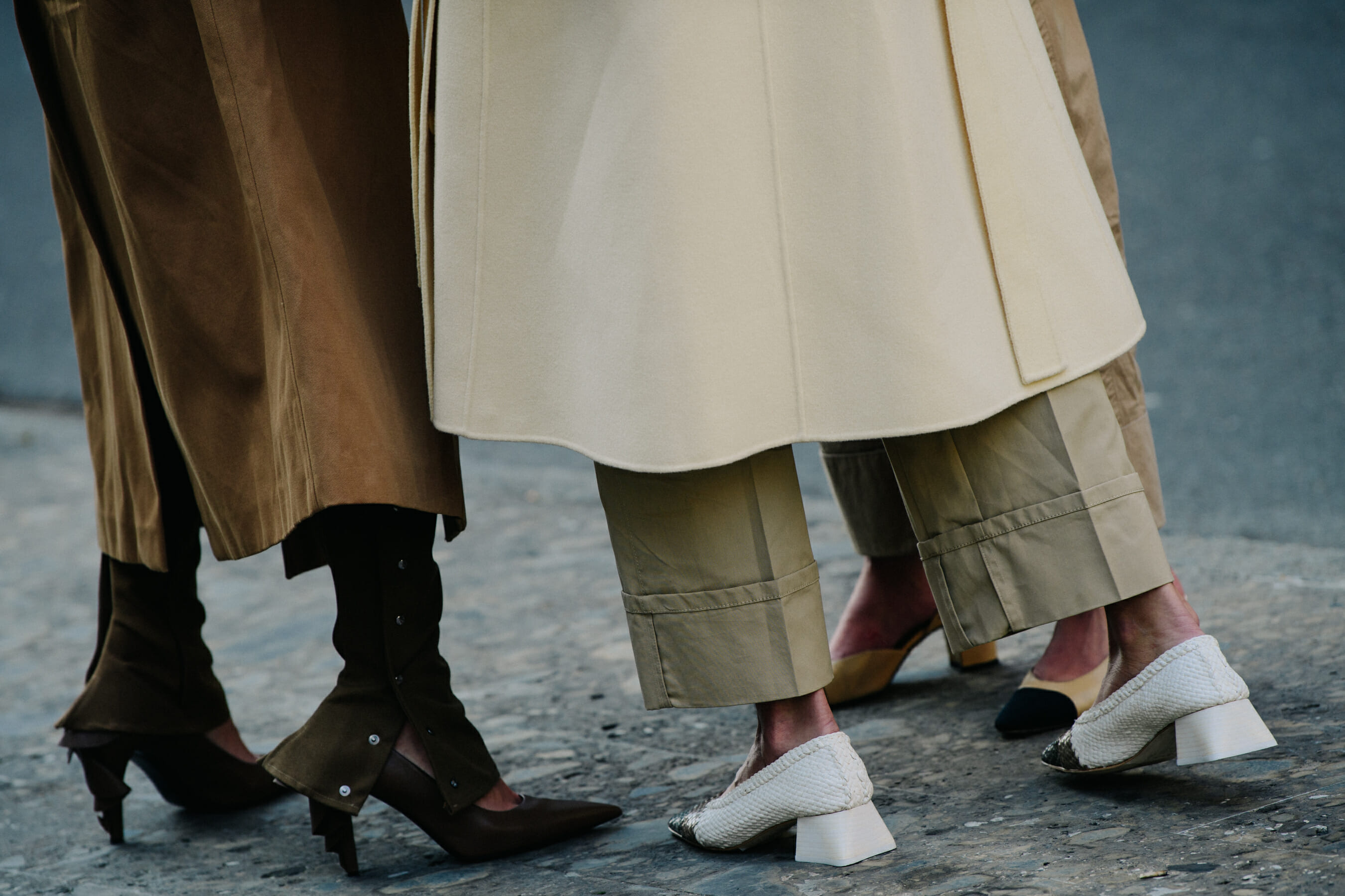 Three women wearing long coats