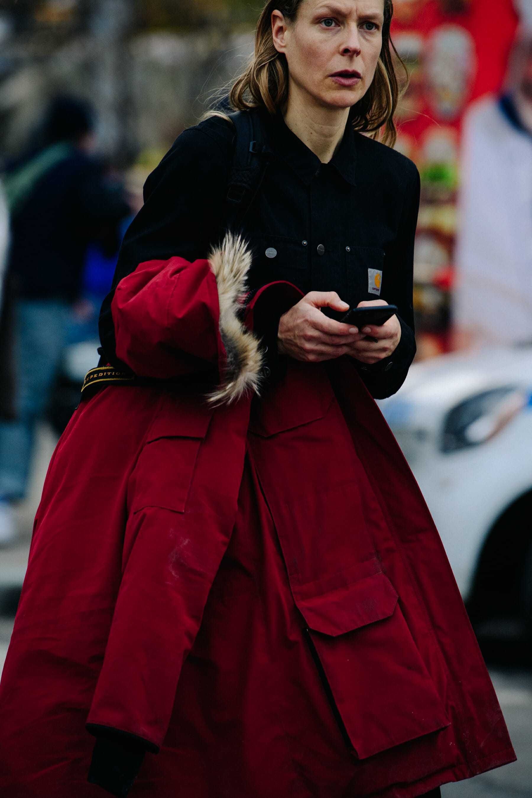 Woman carrying red Canada Goose coat