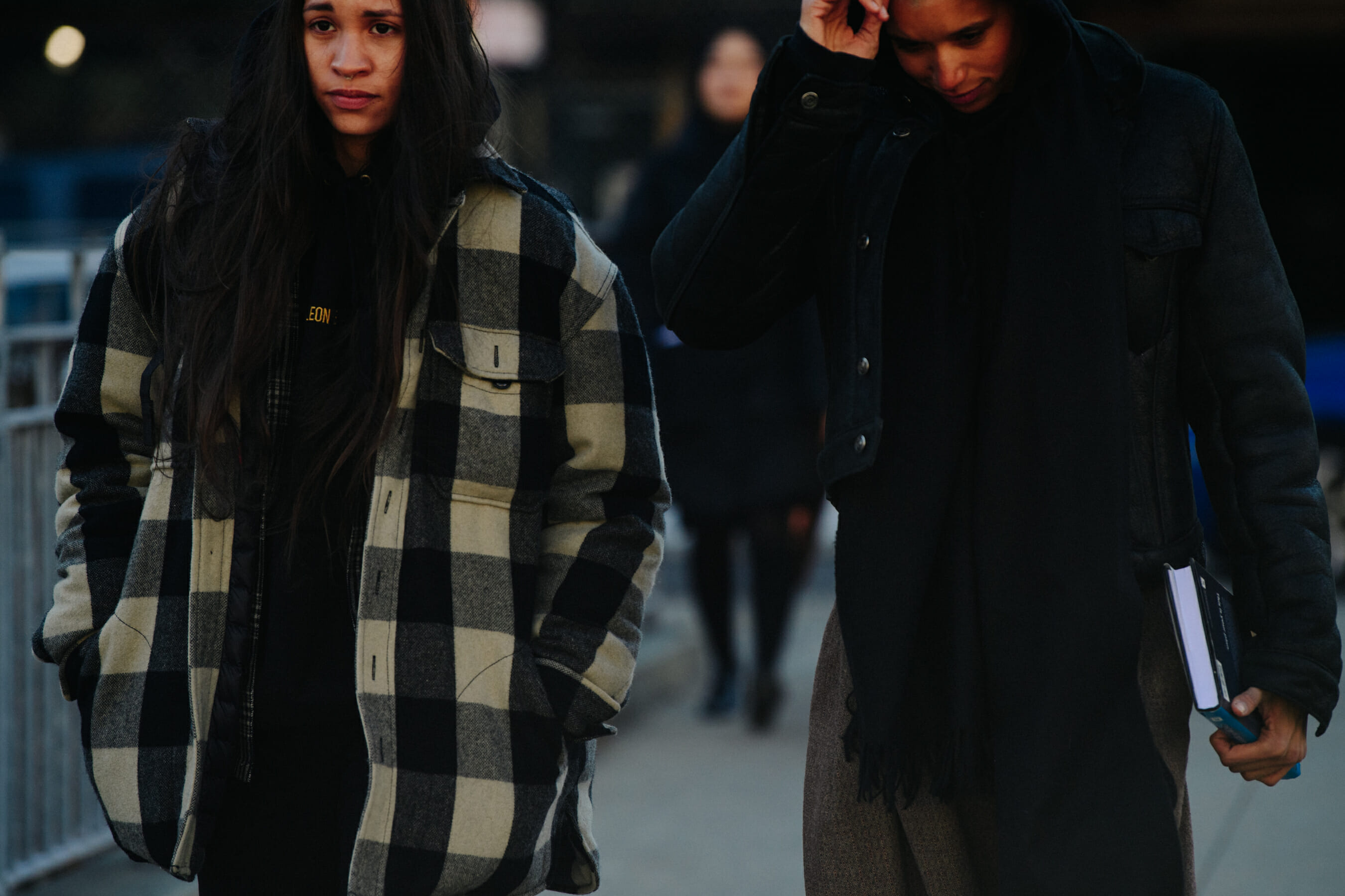 Two models wearing dark outfits