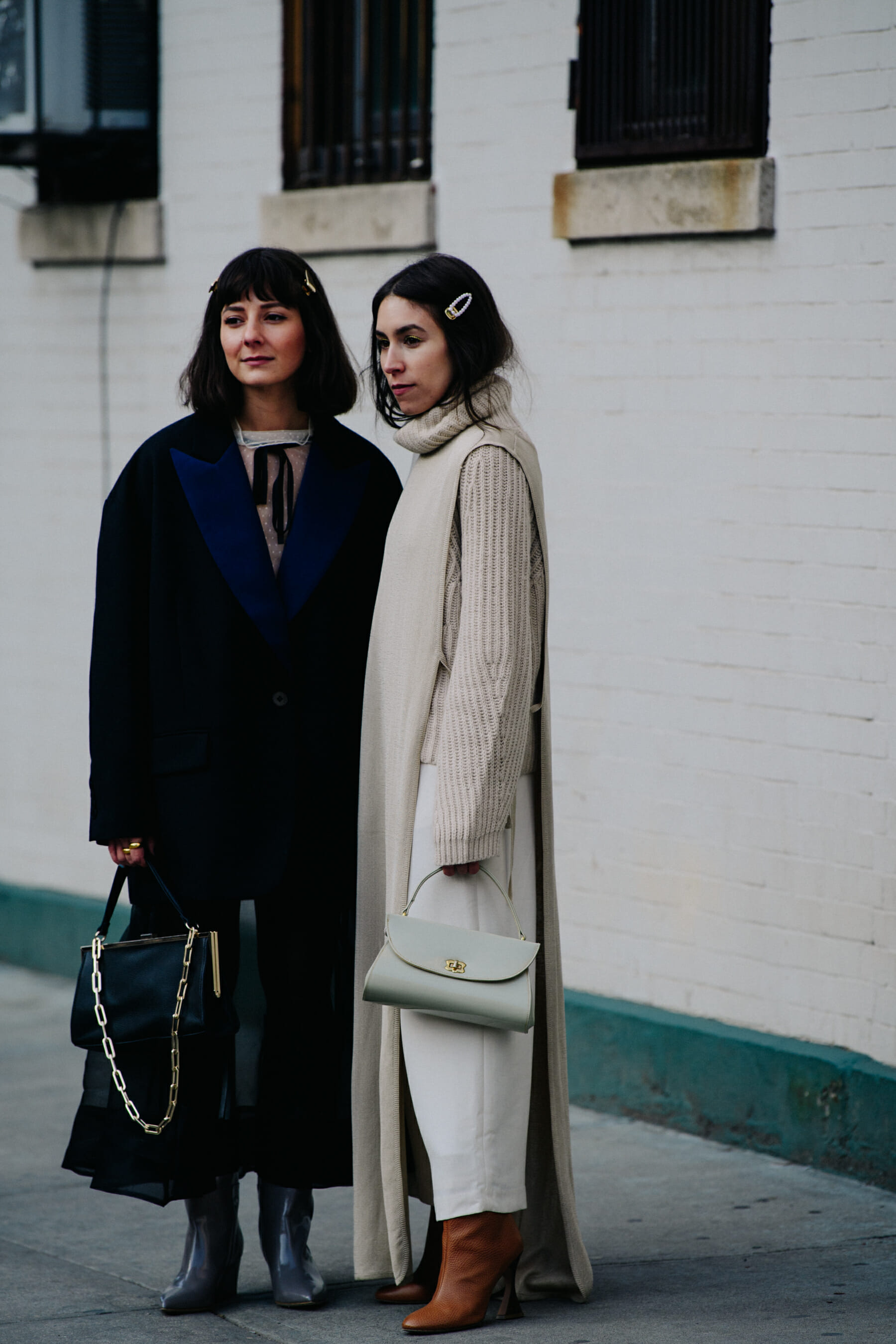 Two bloggers wearing white and black coats