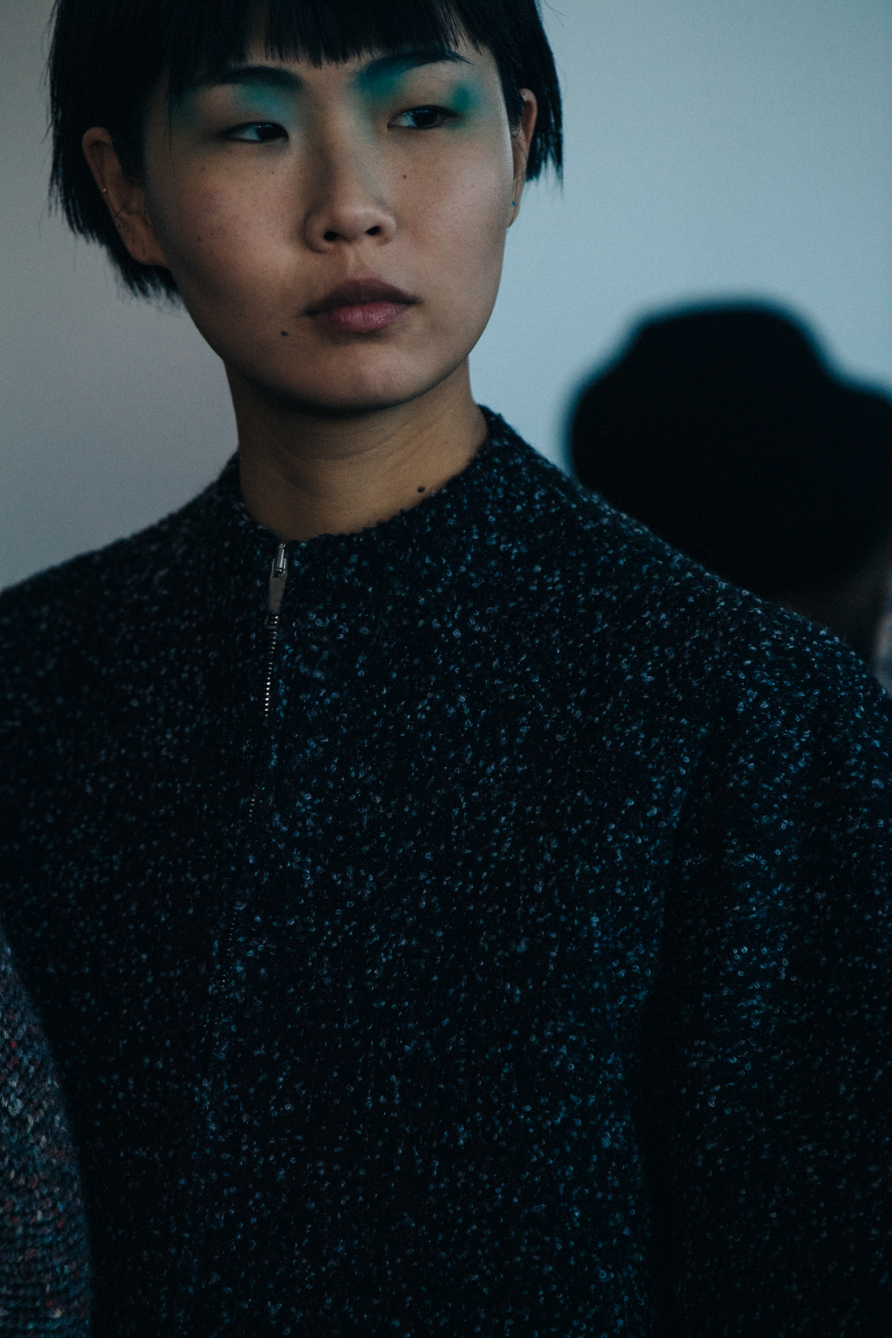 Model backstage wearing colourful makeup