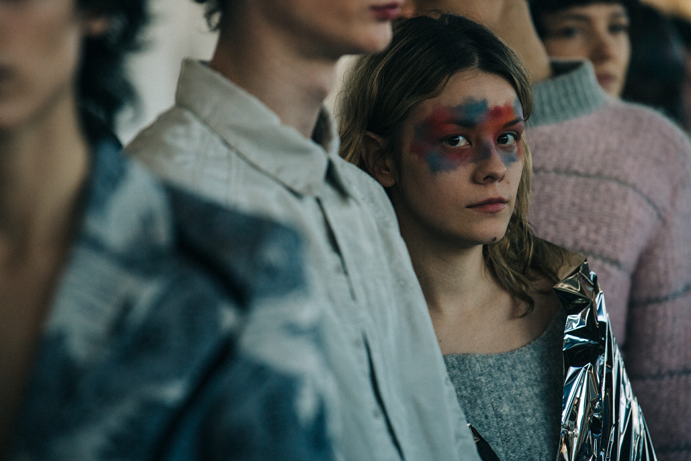 Model backstage wearing colourful makeup