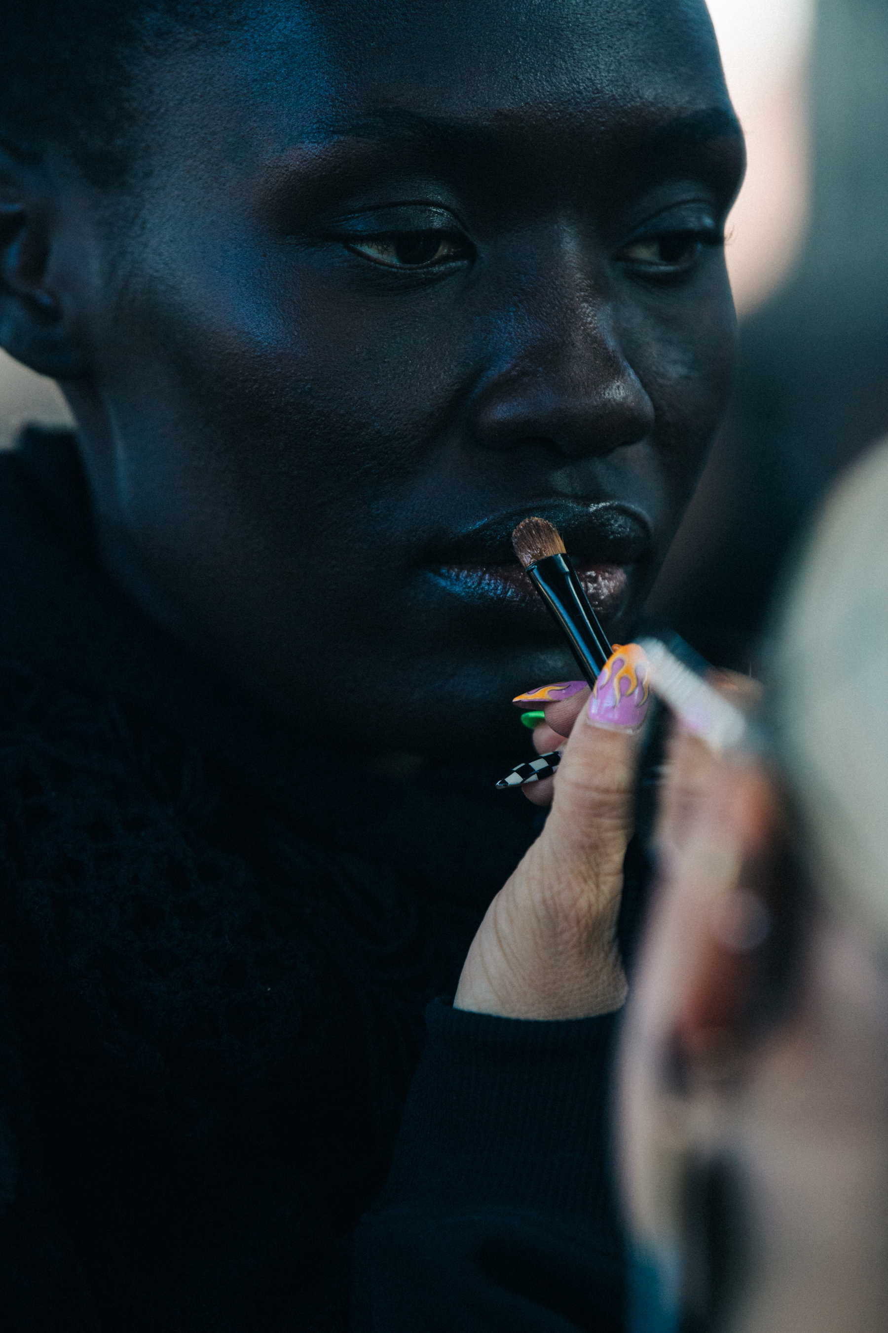 Model backstage wearing colourful makeup