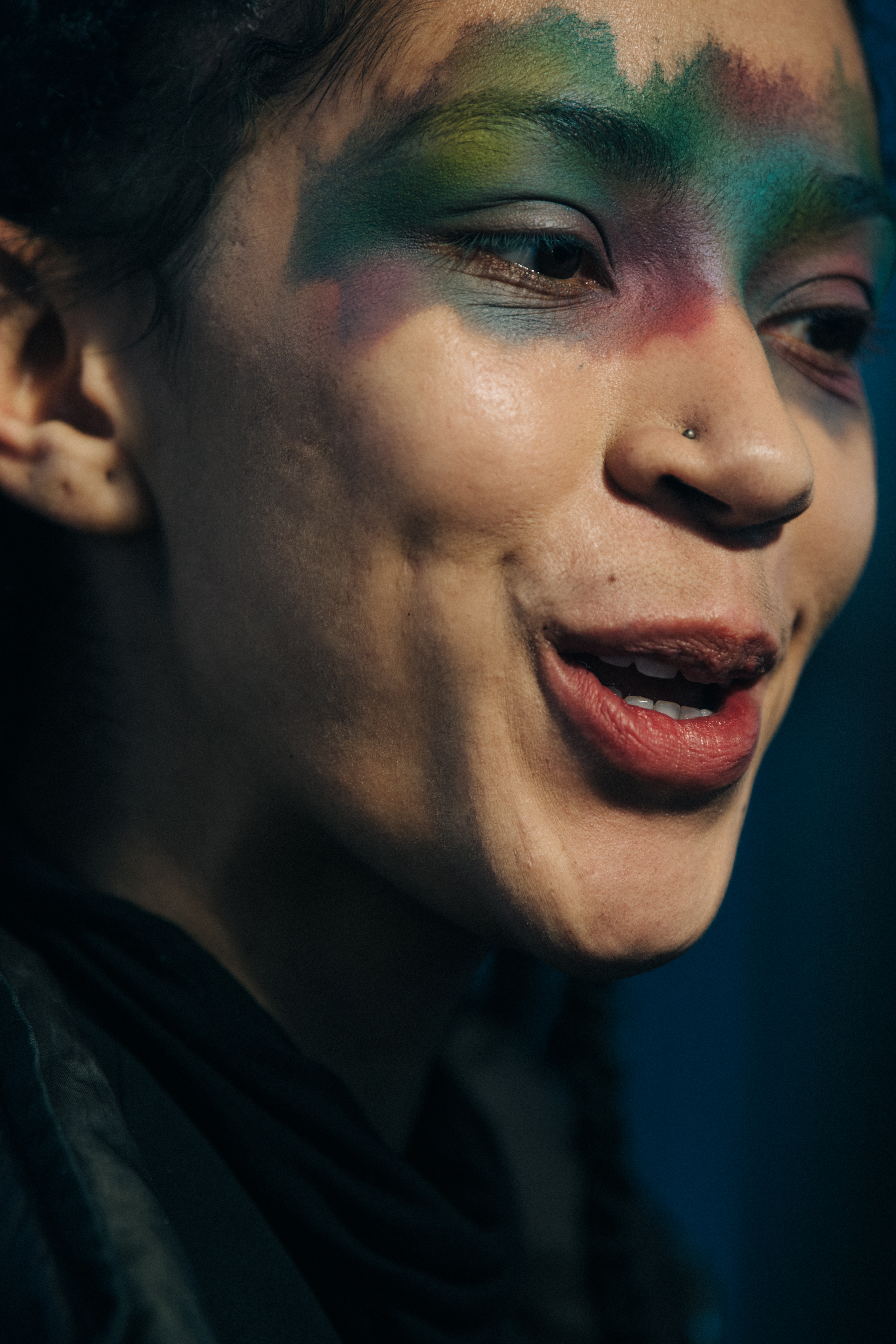 Model backstage wearing colourful makeup