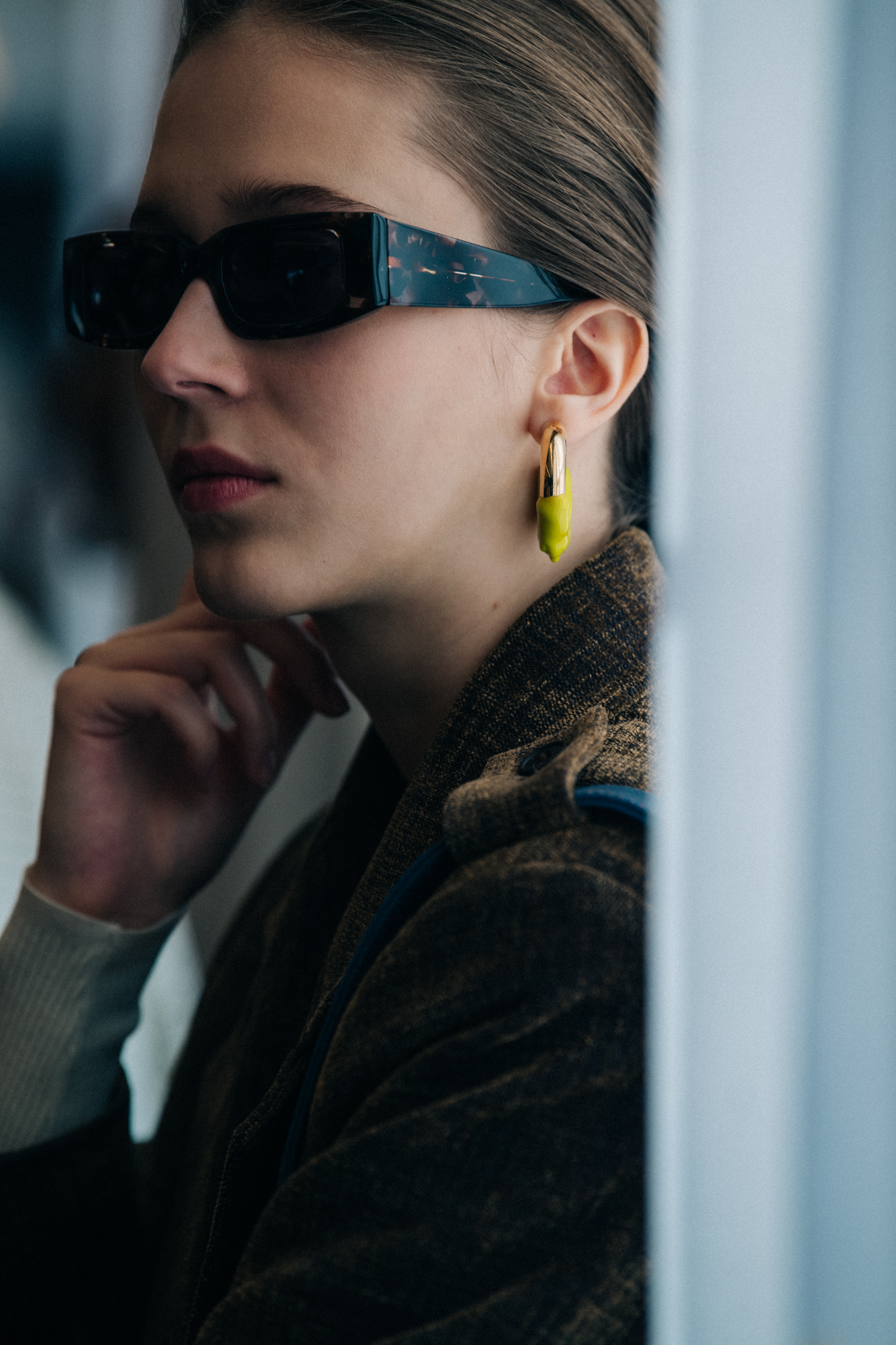 Model wearing high collar backstage at Sunnei