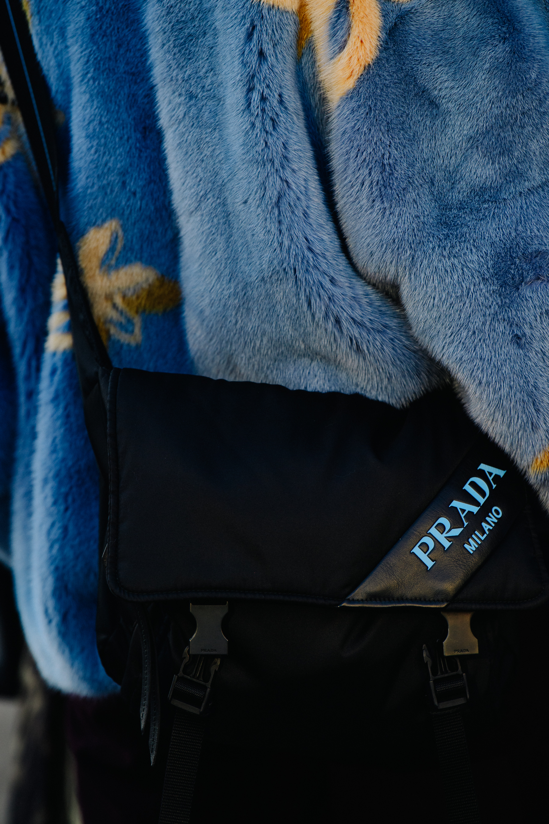 Woman carrying blue Prada bag
