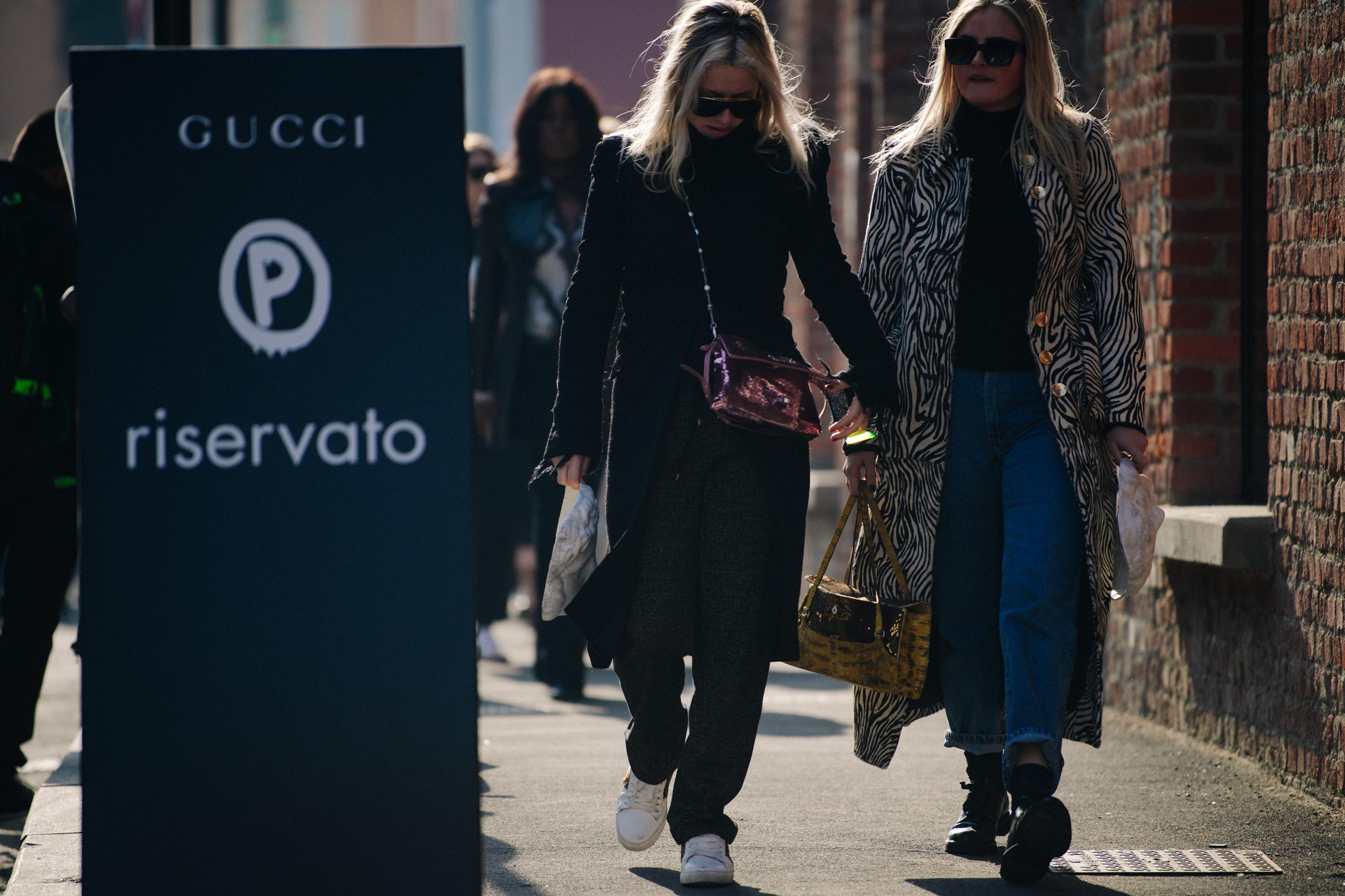 Two women wearing long coats