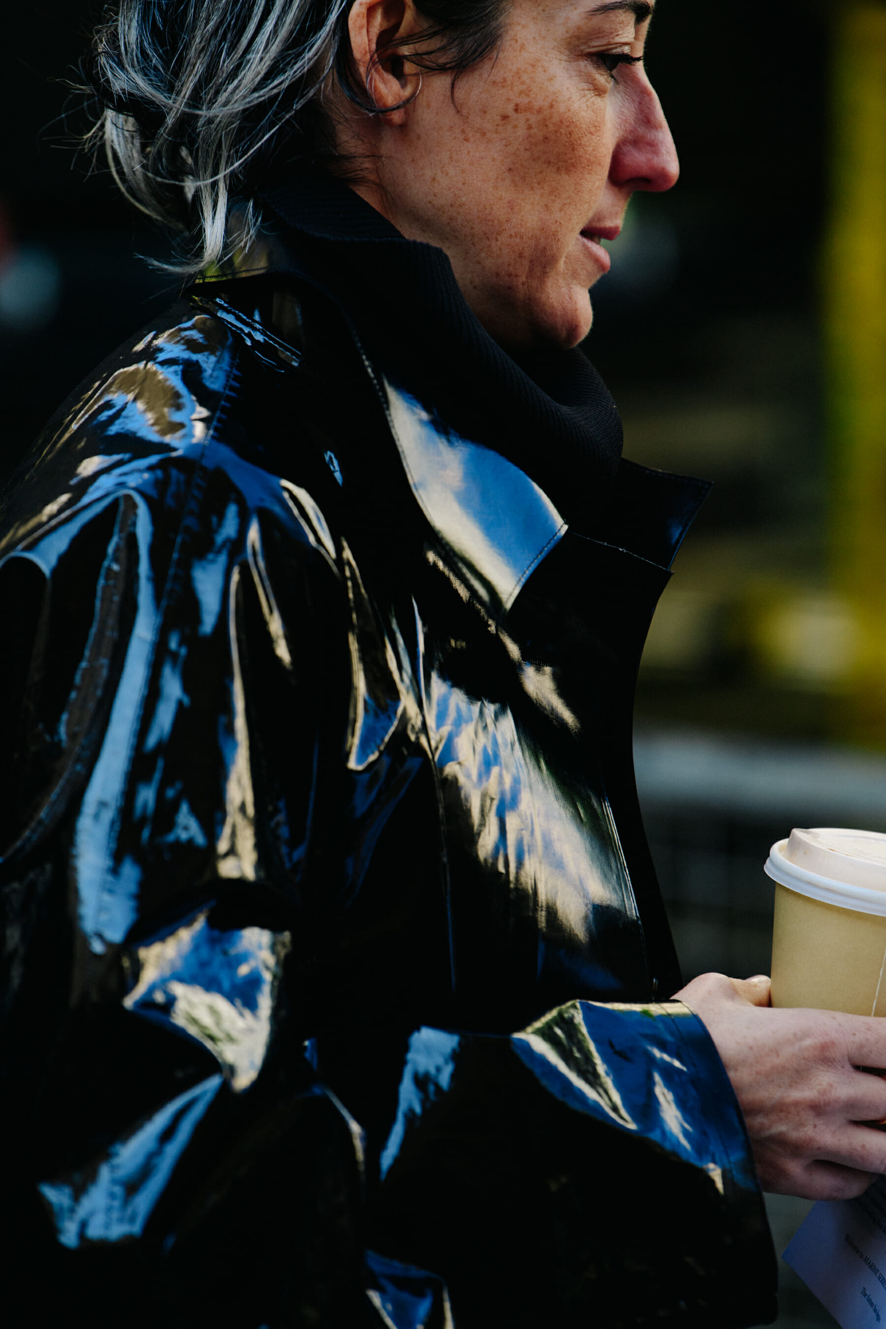Woman wearing black patent coat