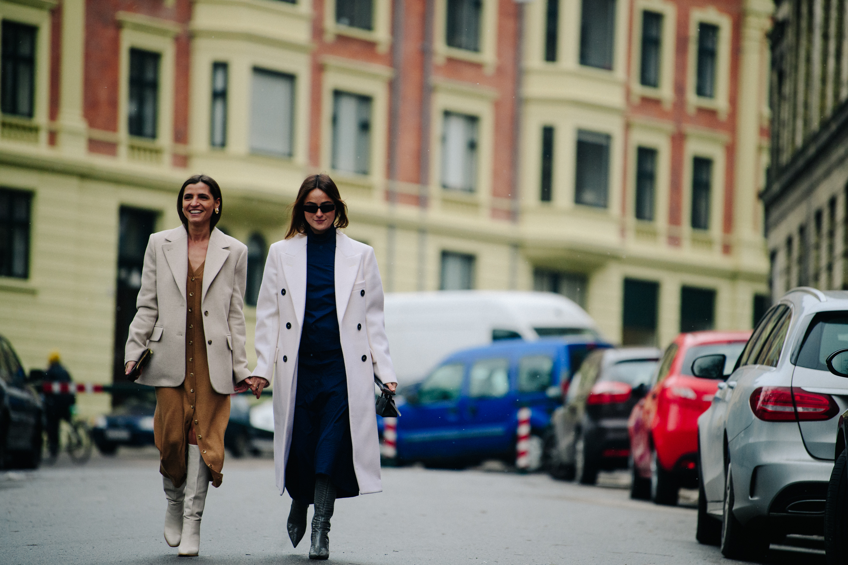 Two women wearing long coats
