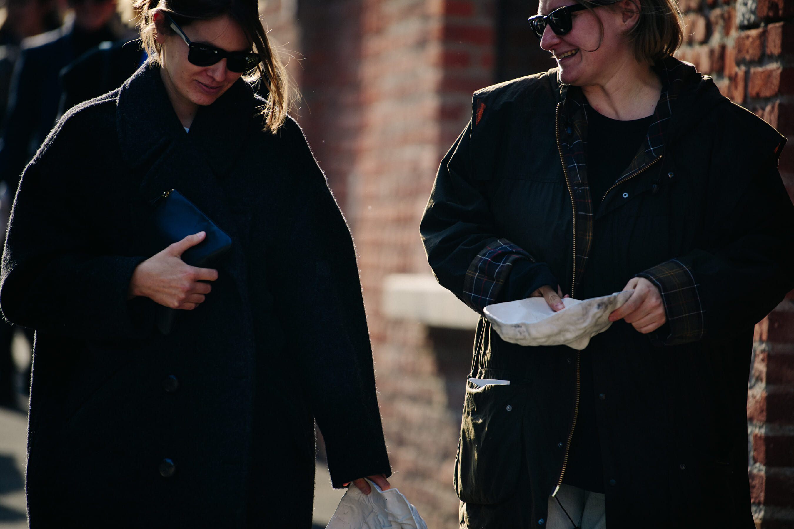 Two women wearing dark coats