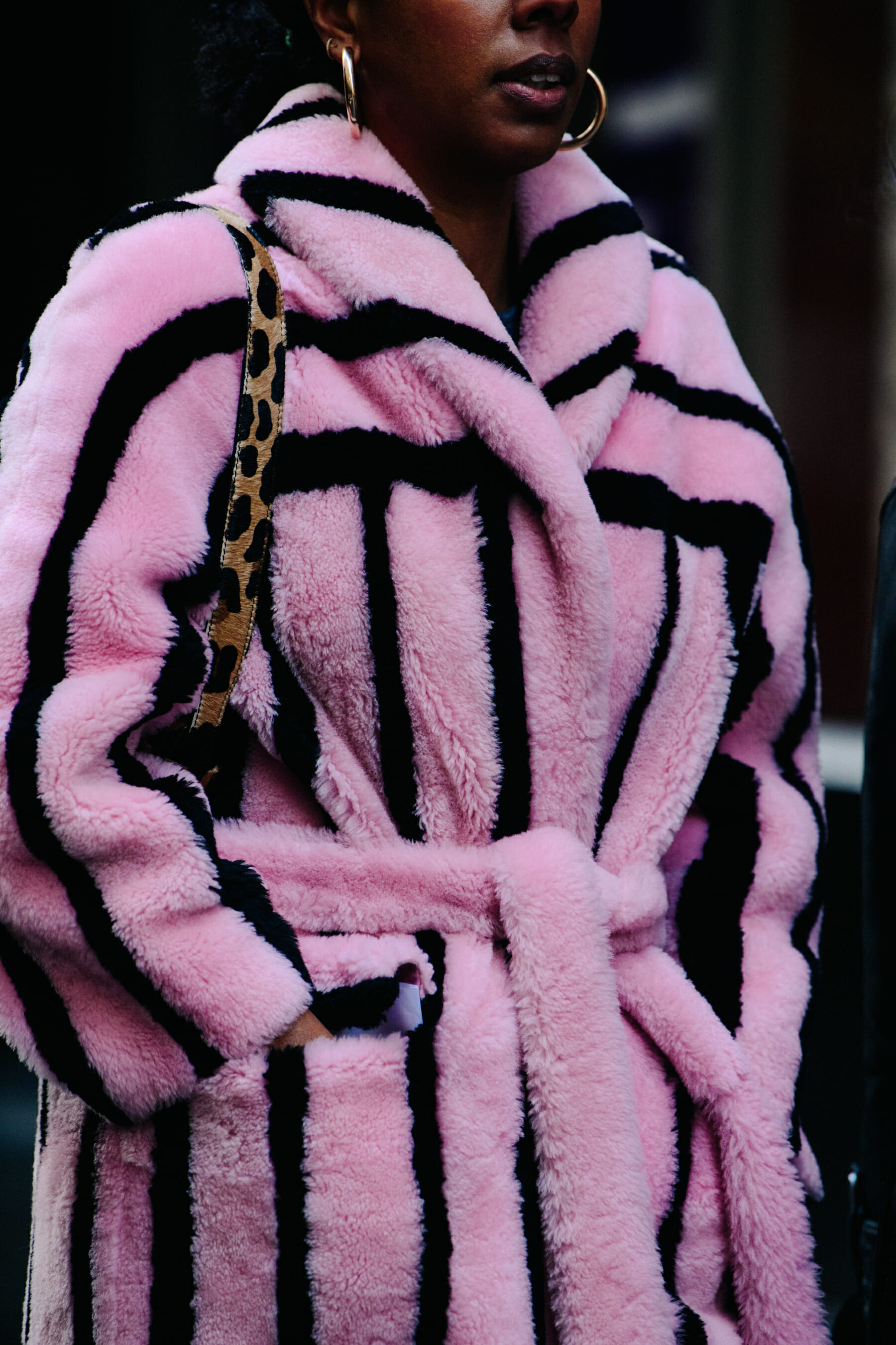 Woman wearing pink fur striped coat