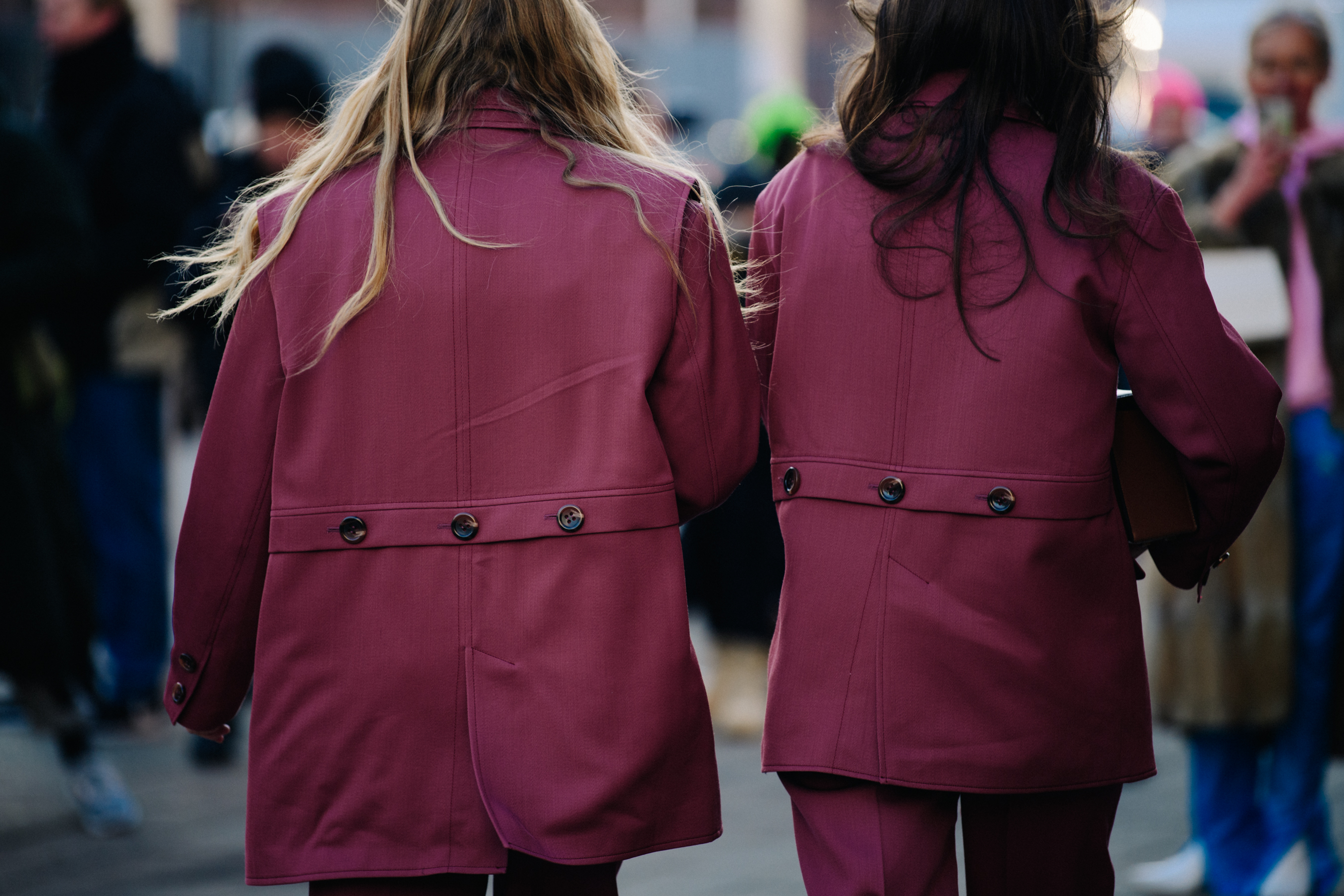 Two women wearing pink coats