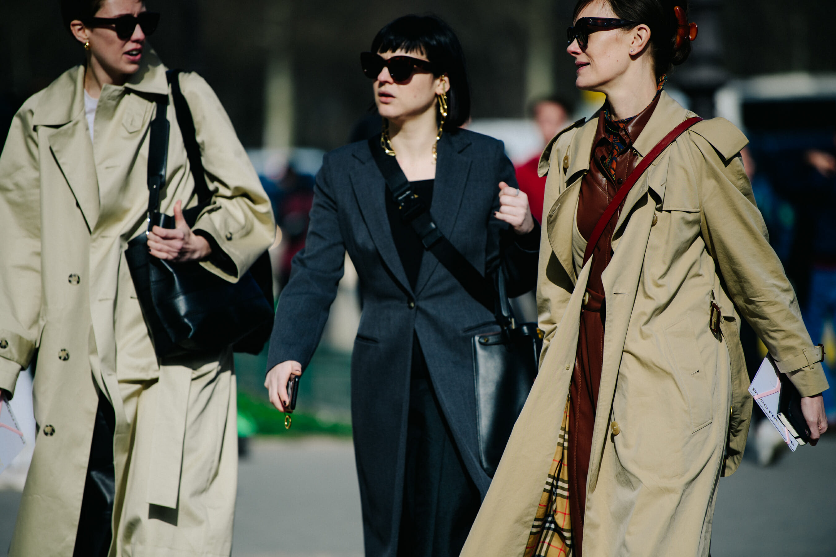 Three women wearing long coats